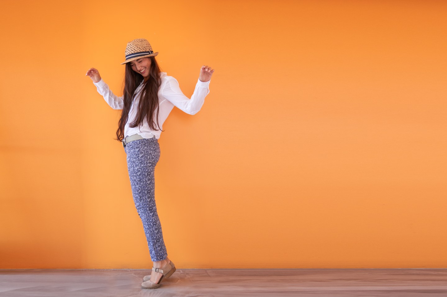 Asian woman smiling in front of orange wall