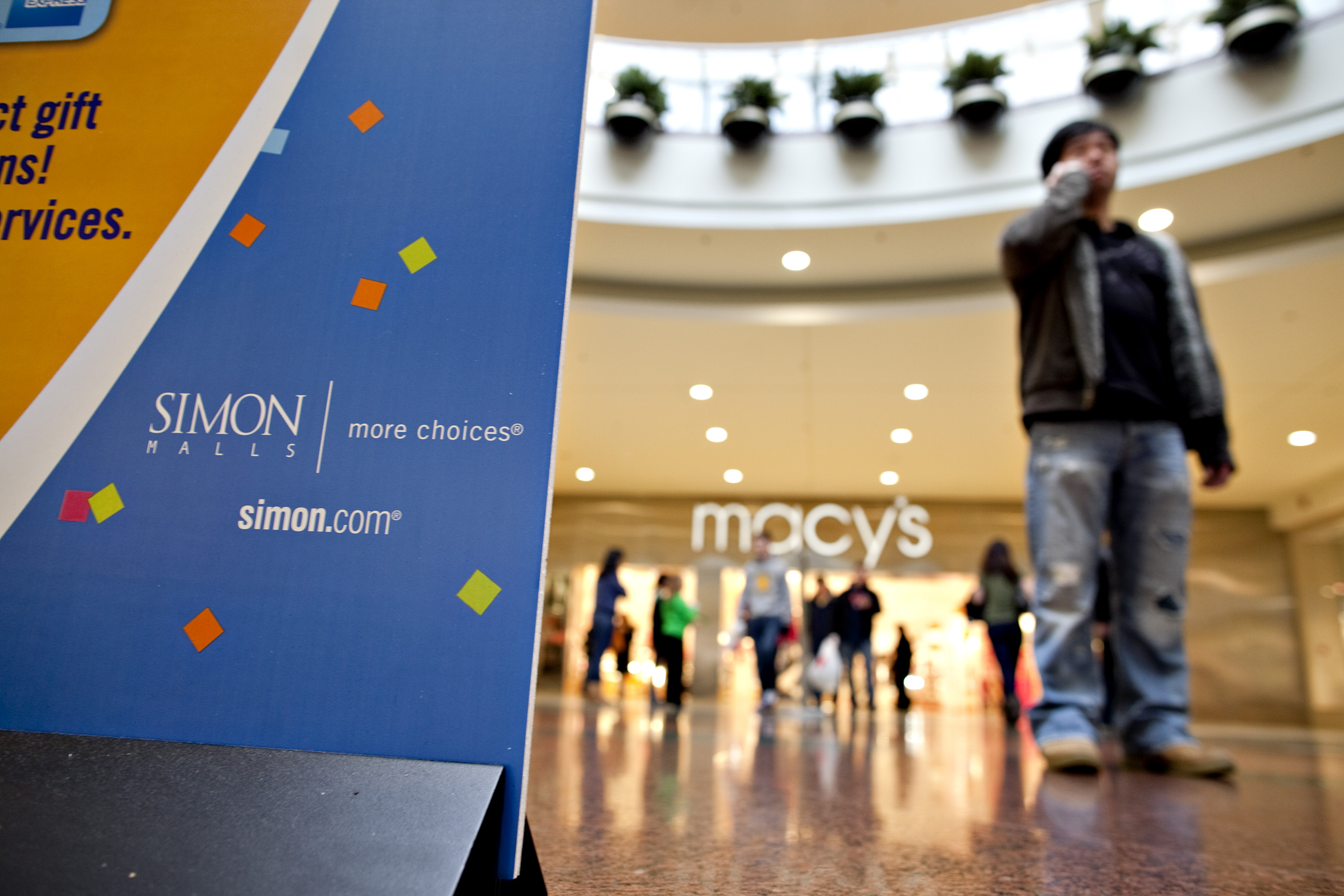 Shoppers walk outside stores at Simon Property Group Inc.'s Roosevelt Field Mall in Garden City, U.S., on Tuesday, Feb. 16, 2010. Simon Property Group Inc. offered to buy General Growth Properties Inc. out of bankruptcy for more than $10 billion and combine the two biggest U.S. mall owners. Photographer: Daniel Acker/Bloomberg