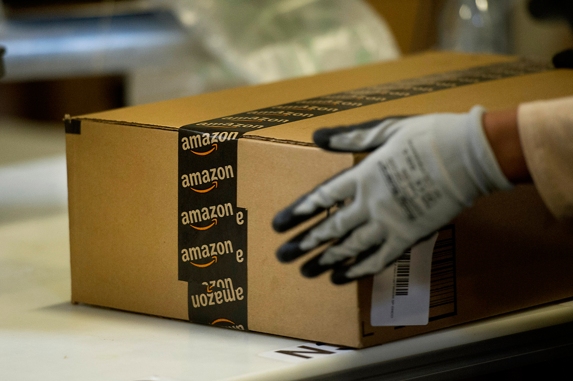 An employee seals a box at the Amazon.com Inc. fulfillment center in Phoenix, Arizona, U.S. on Monday, Dec. 2, 2013. More than 131 million consumers are expected to shop Cyber Monday events, up from 129 million last year, according to the National Retail Federation. Photographer: David Paul Morris/Bloomberg
