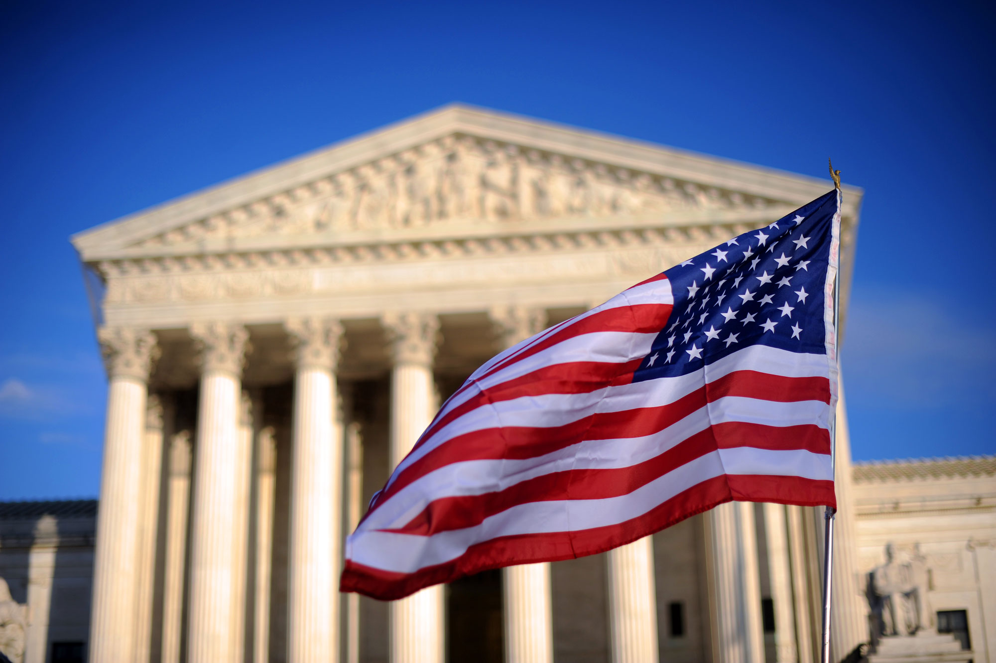 A US flag is held by a marcher in front