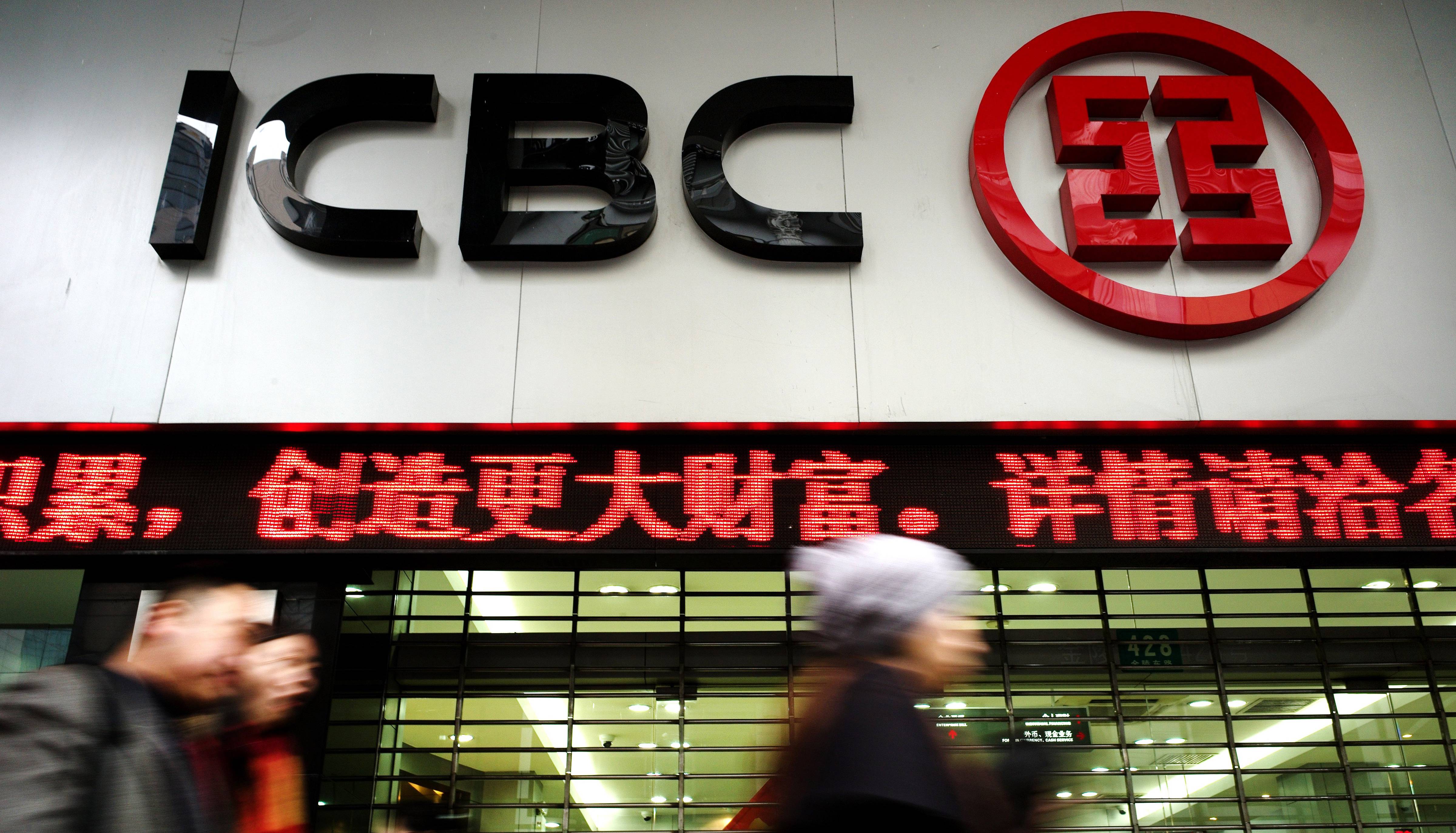 Pedestrians walk past a branch of China'
