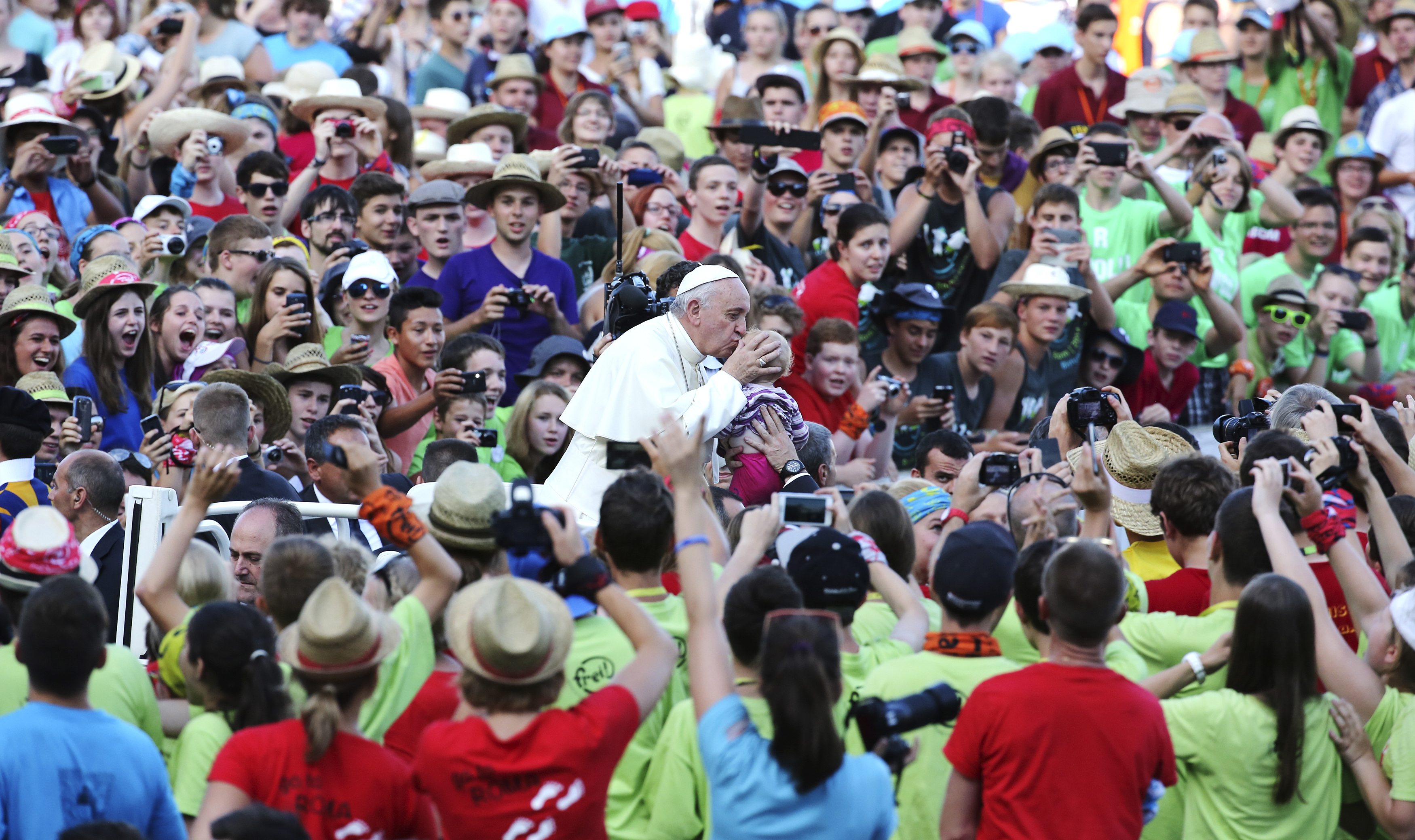 Pope Francis kisses a child as he arrives to leads a meeting with altar workers in St Peter's square at the Vatican