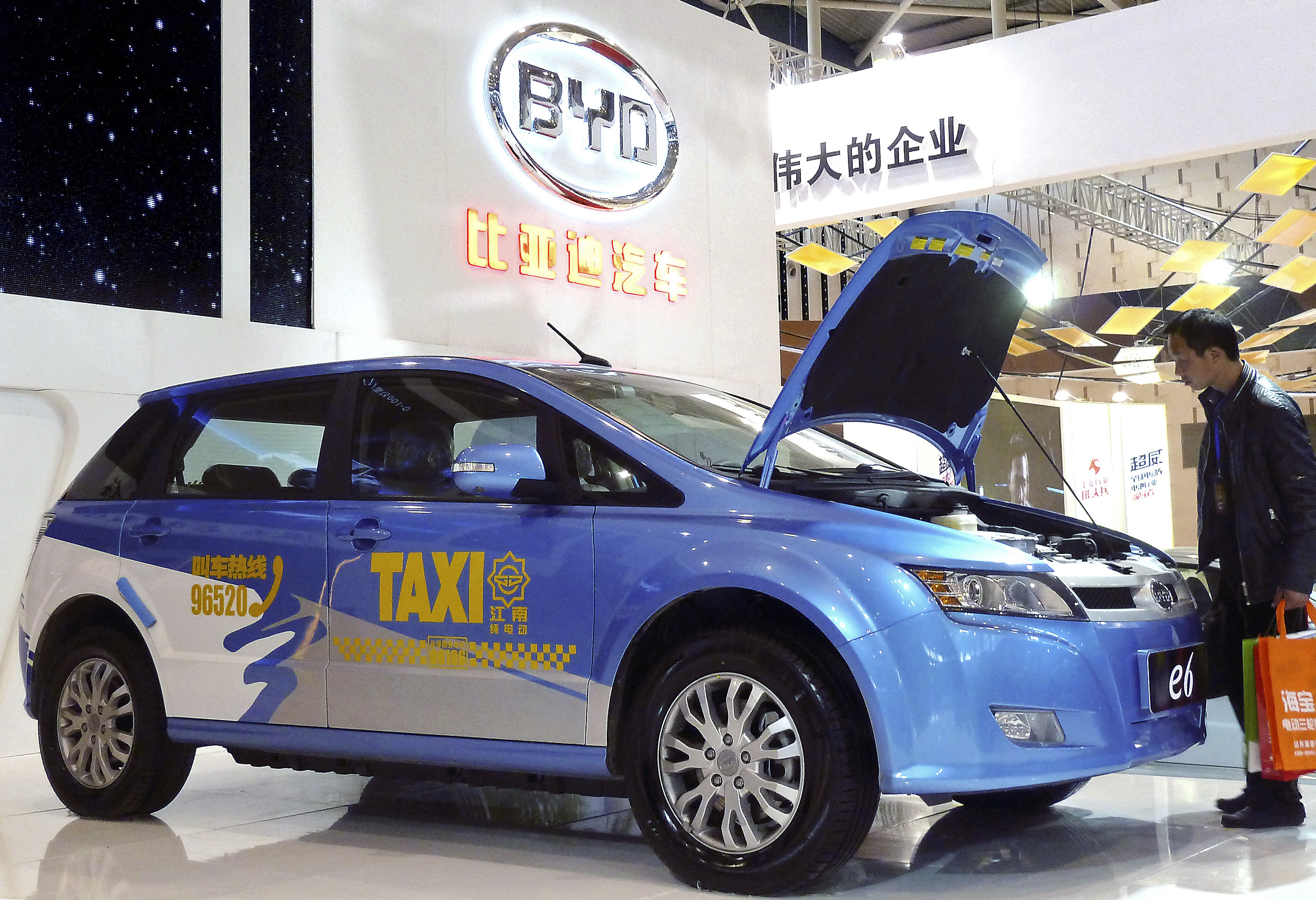 A visitor looks at BYD E6 electric car on display at the New Energy Auto Expo in Nanjing