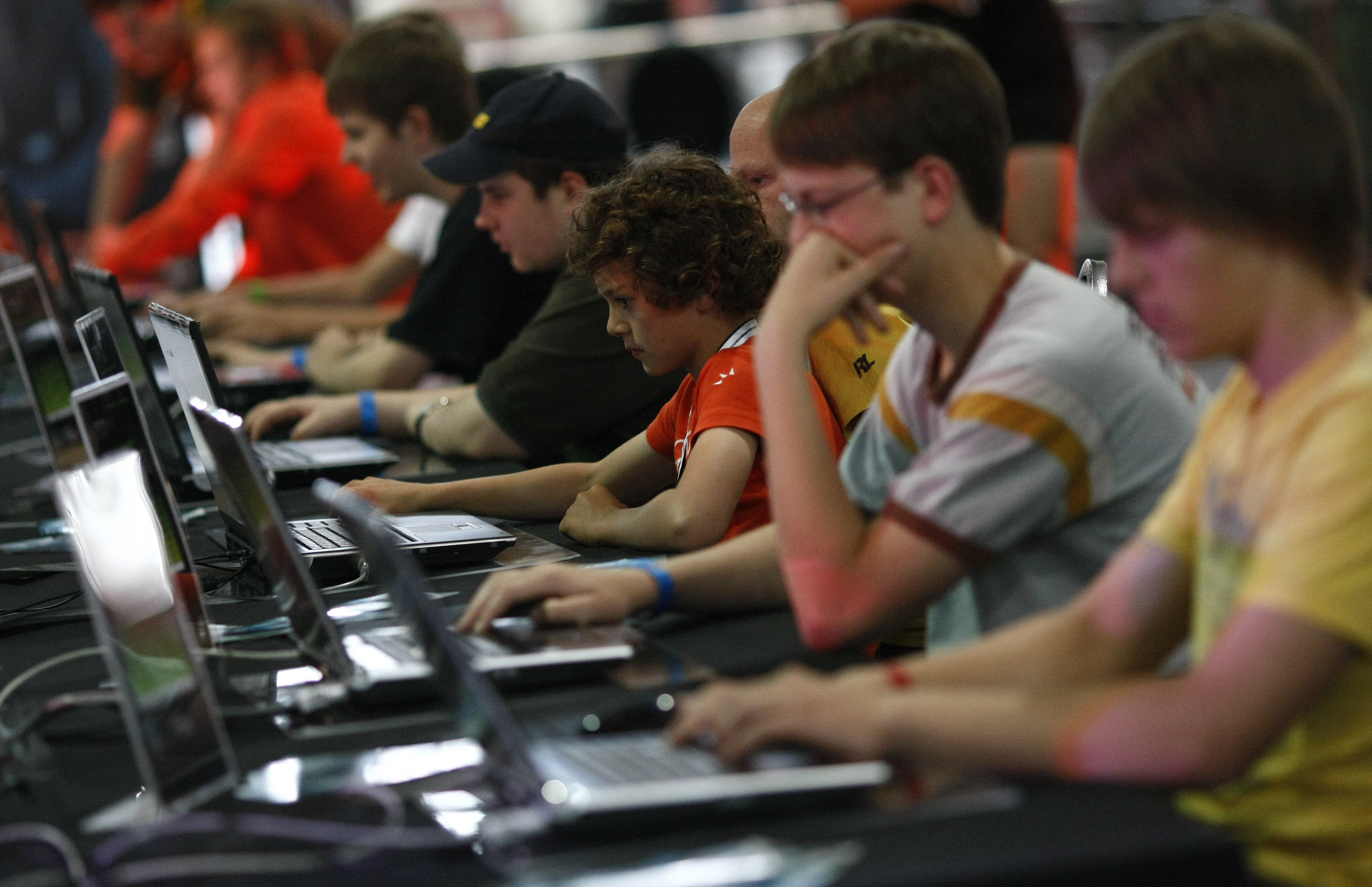 Visitors play at an exhibition stand at the Games Convention Online 2009 fair in Leipzig