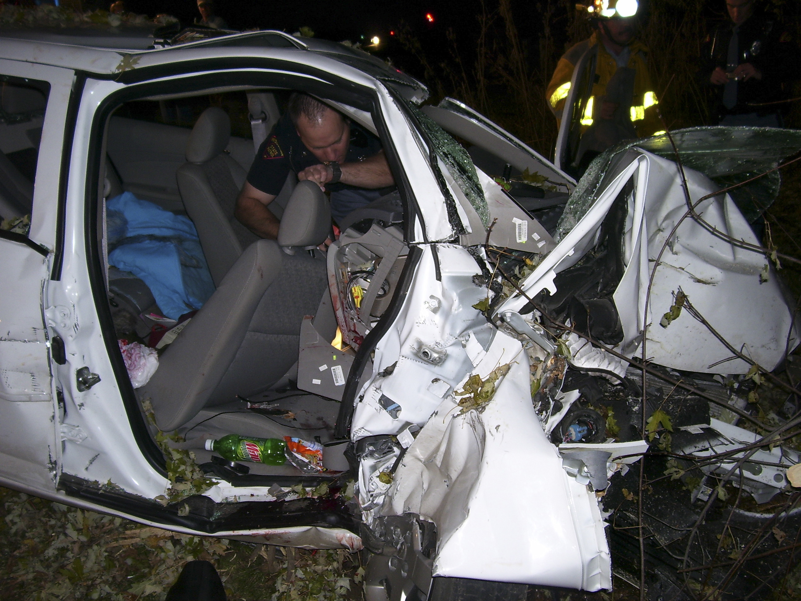 File photo of a police officer looking through the wreck of a 2005 Chevy Cobalt in St Croix County, Wisconsin