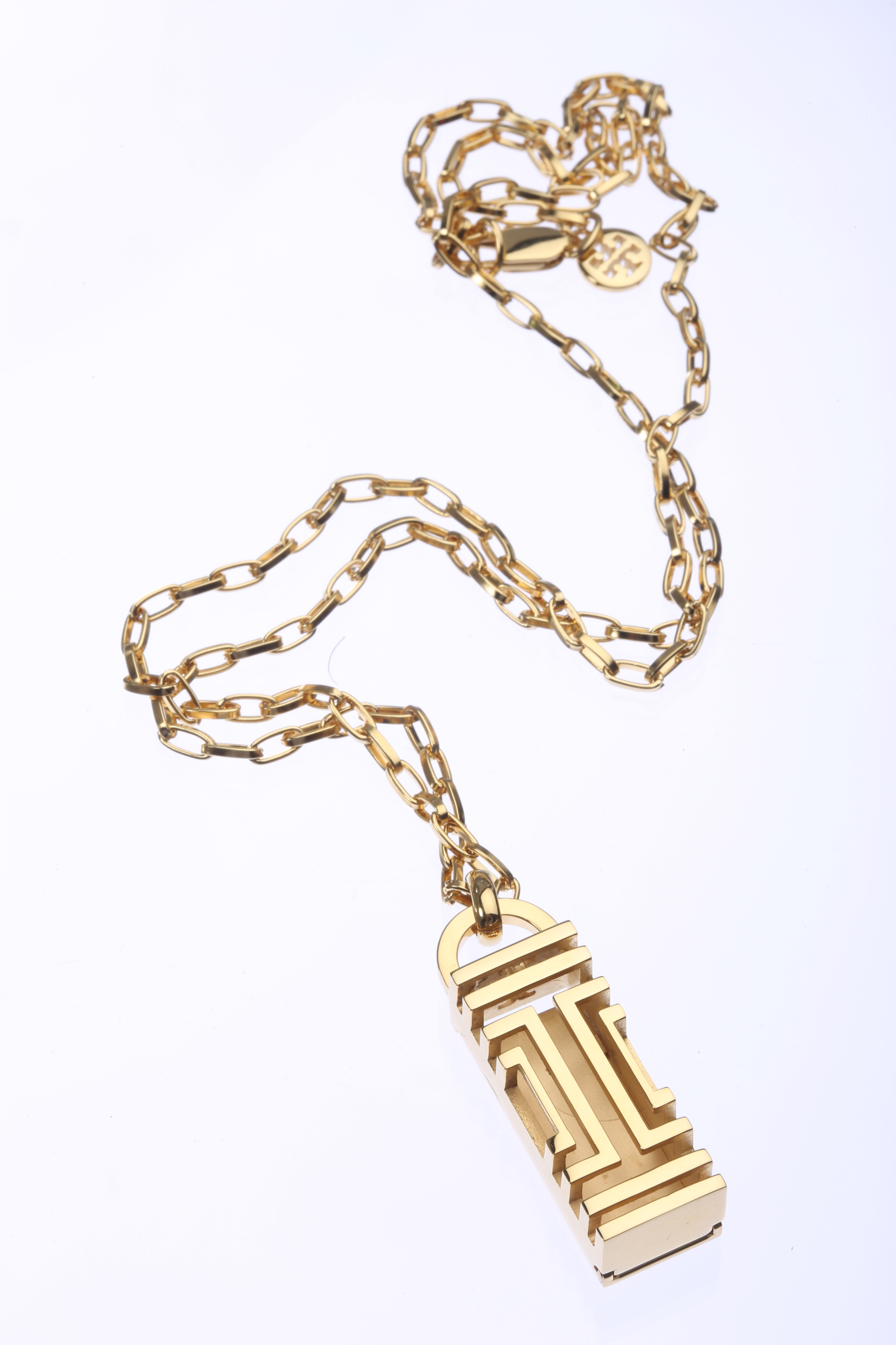 A Fit Bit necklace in gold from Tory Burch.