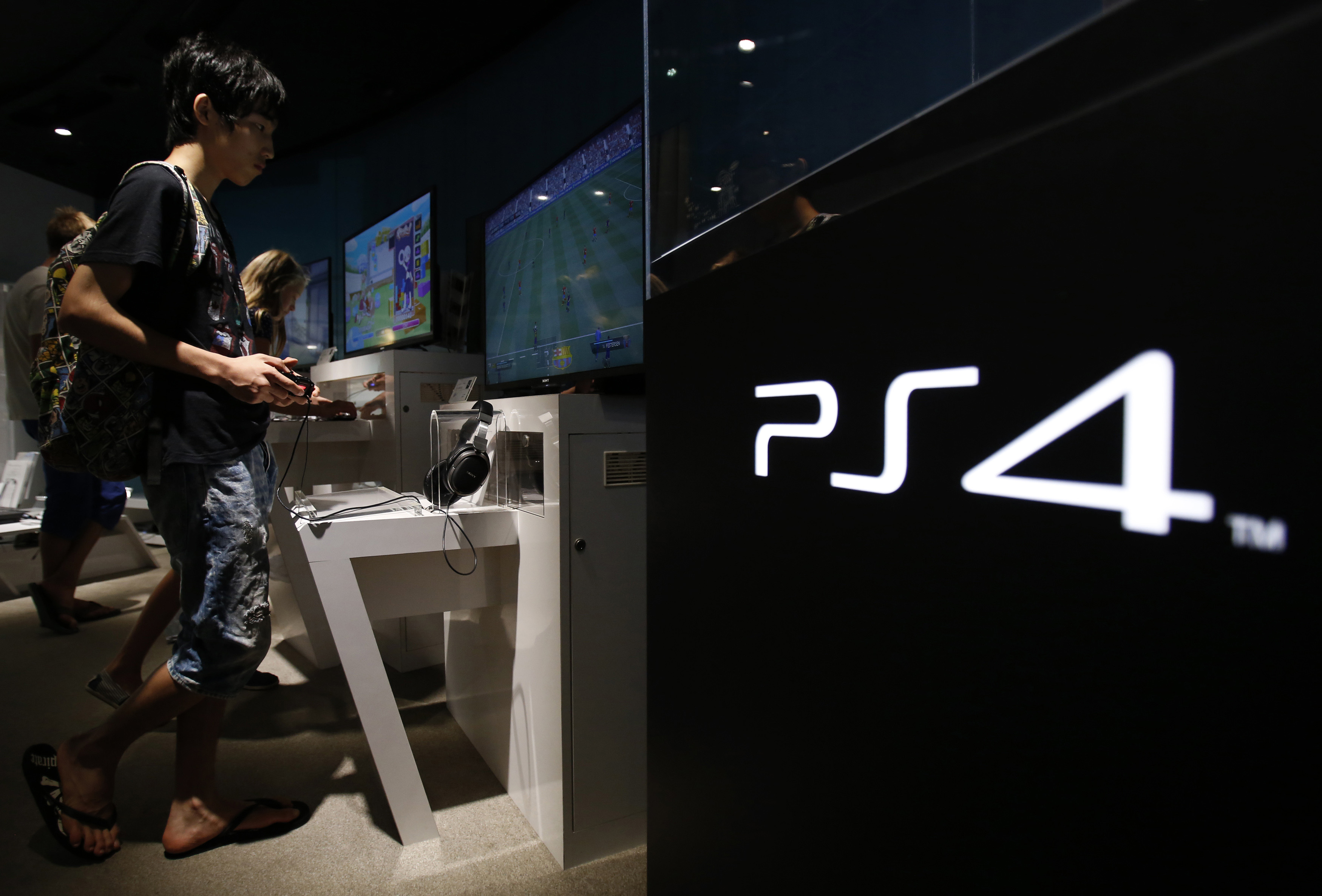 A man plays a video game on Sony Corp's Play Station 4 console at its showroom in Tokyo