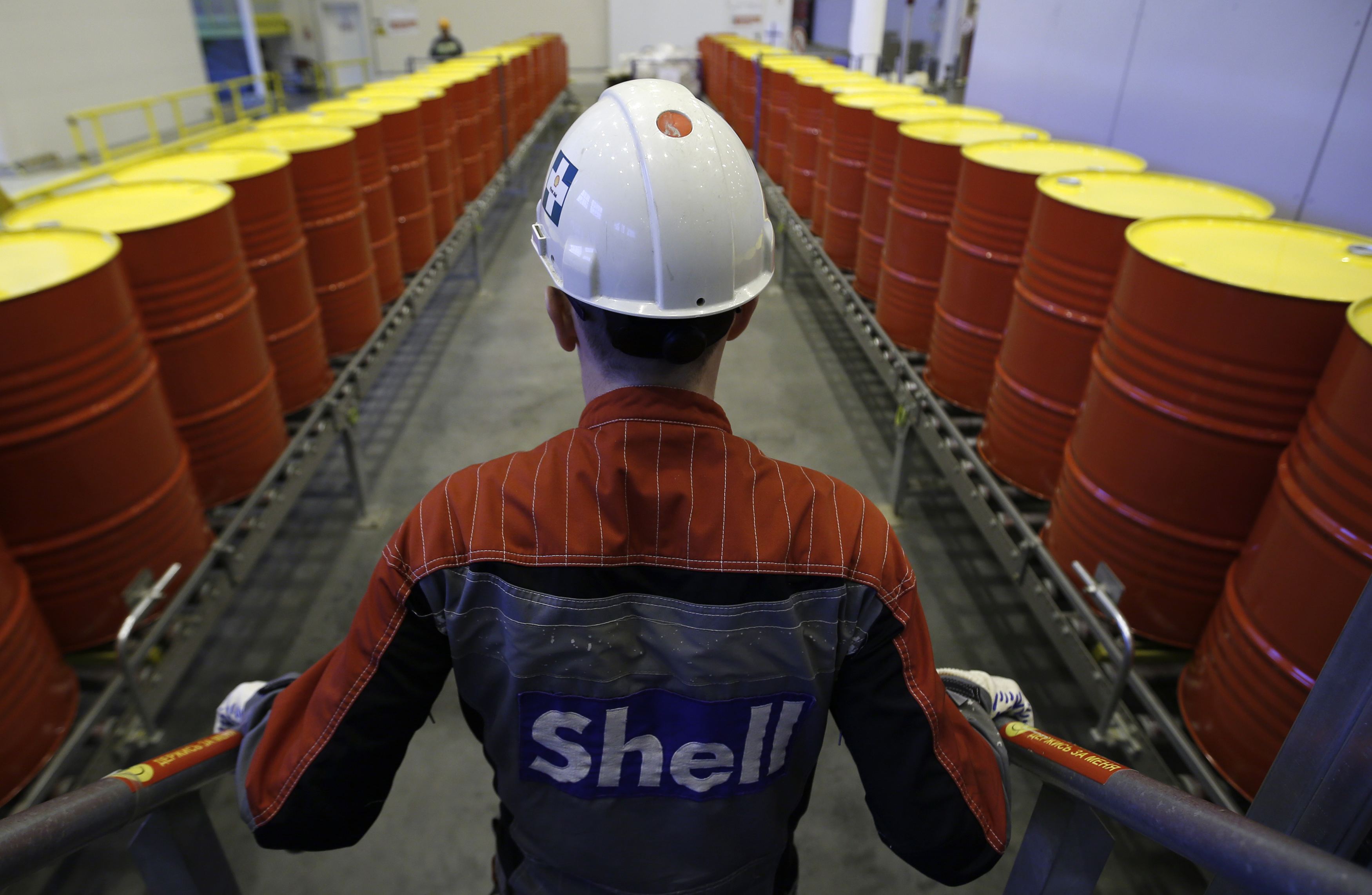 An employee stands in front of lines of oil barrels at Royal Dutch Shell Plc's lubricants blending plant in the town of Torzhok