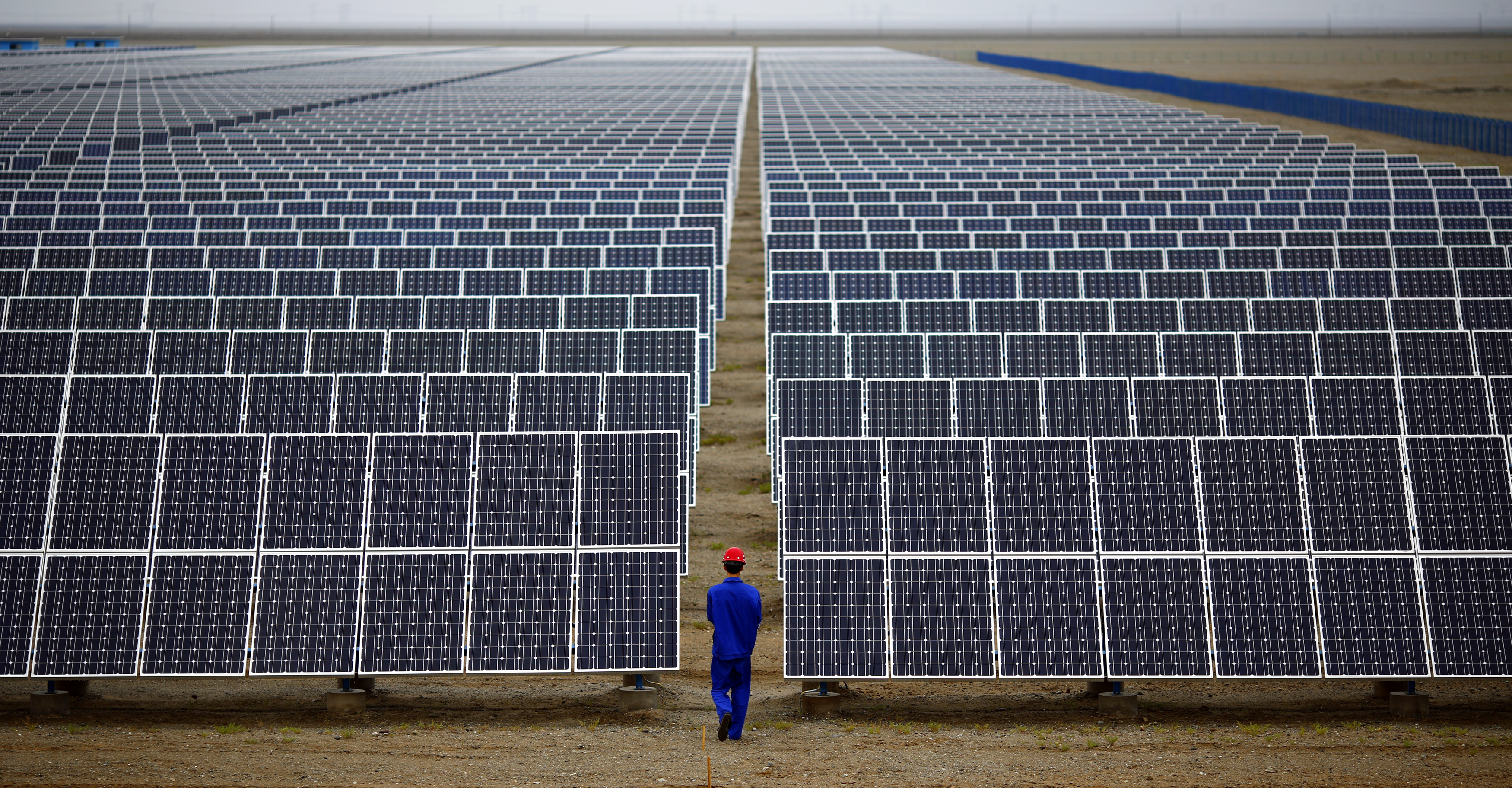 A worker inspects solar panels at a solar farm in Dunhuang, 950km northwest of Lanzhou, Gansu Province