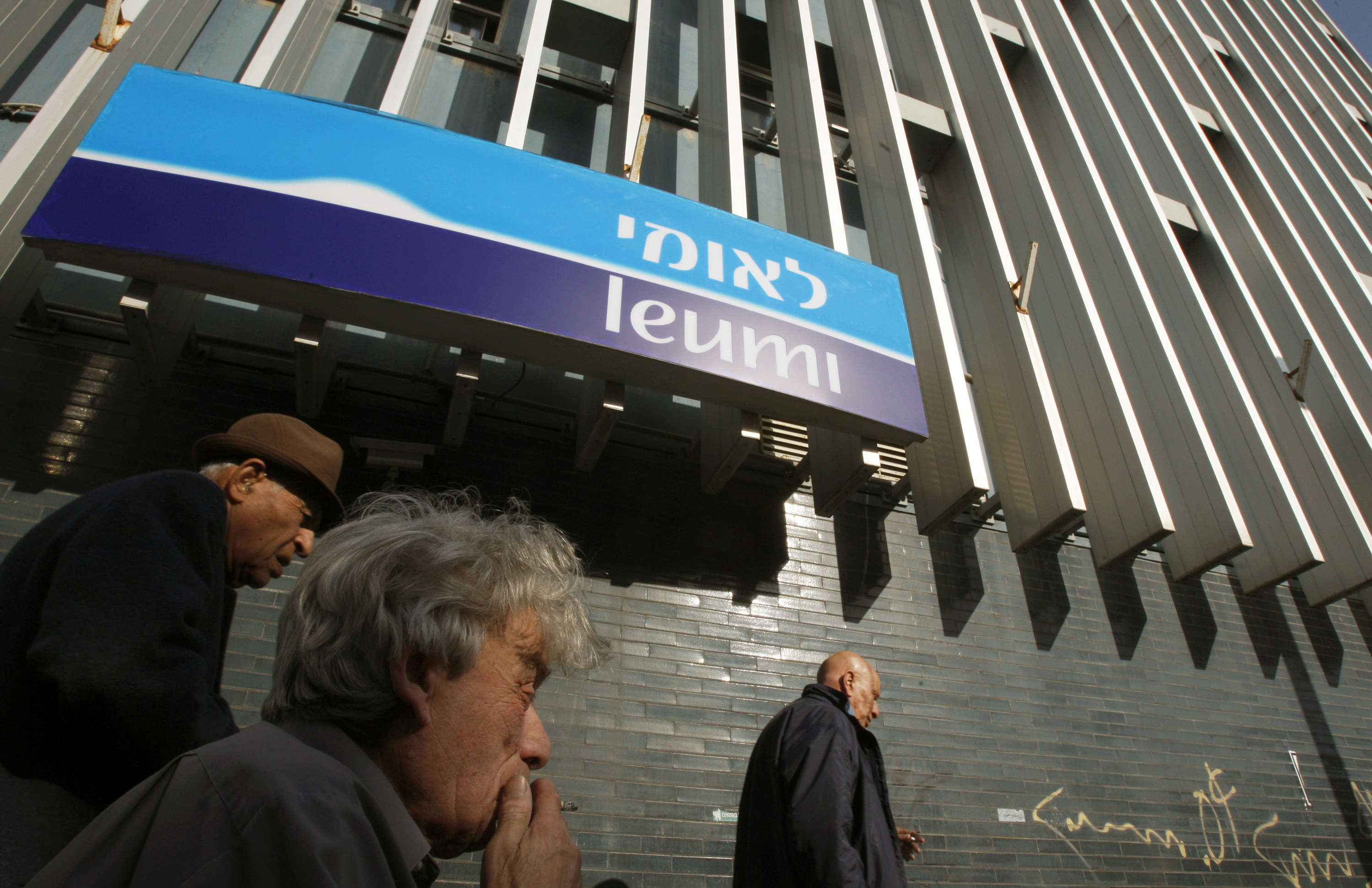 Israelis walk past branch of Bank Leumi in Tel Aviv