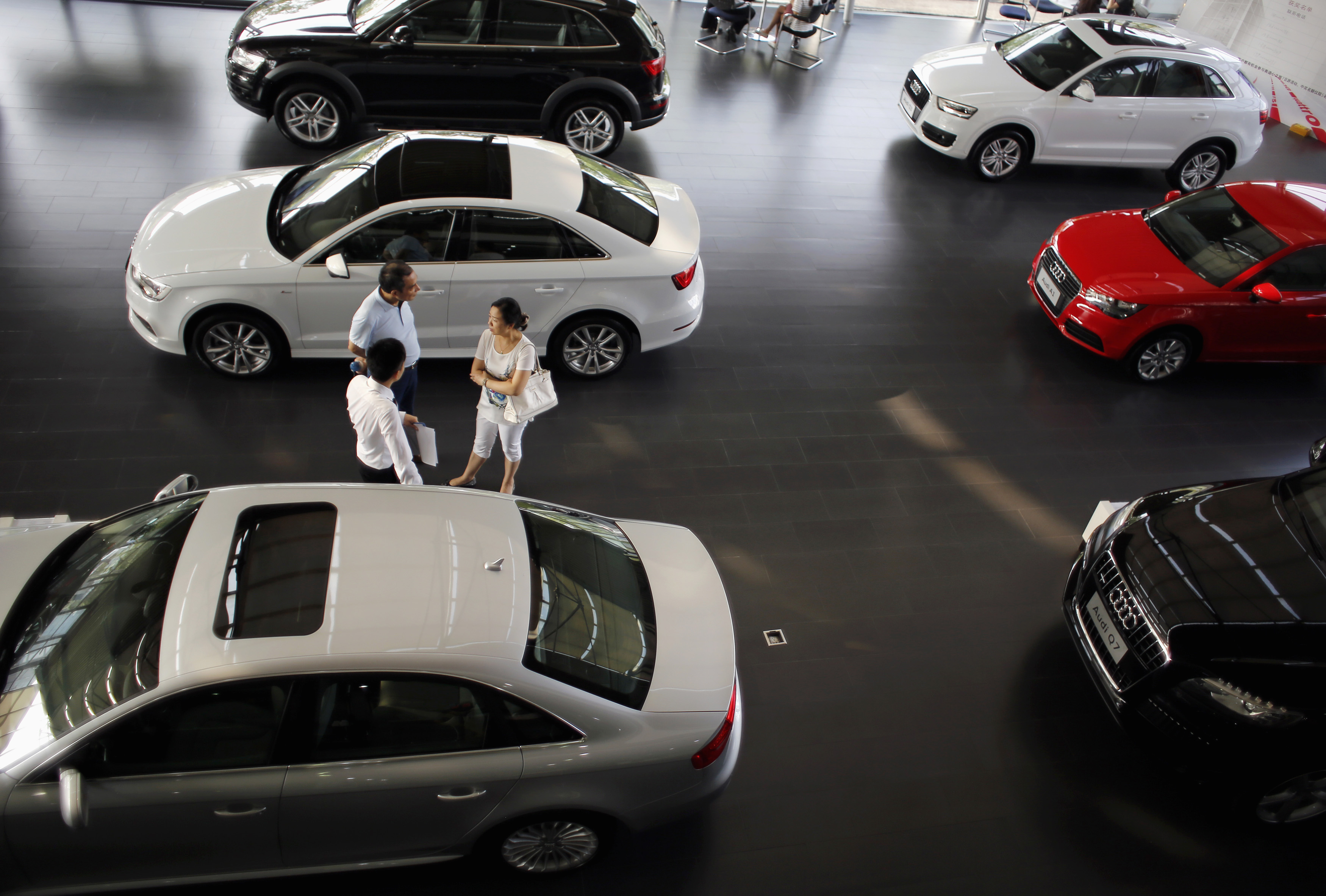 Customers look at a car inside an Audi dealership in Shanghai