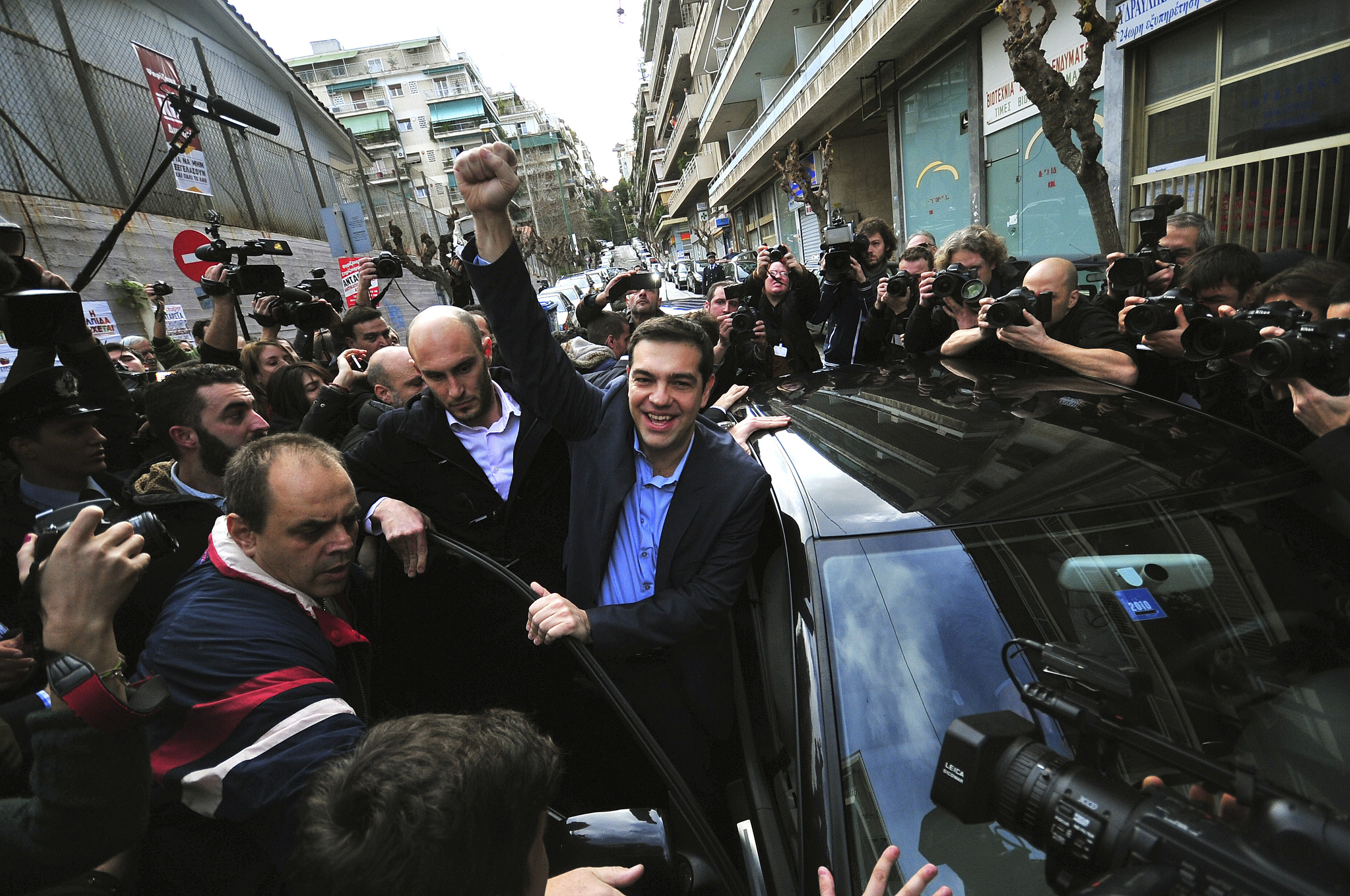 Opposition leader and head of radical leftist Syriza party Alexis Tsipras raises his fist as he leaves a polling station where he voted in Athens