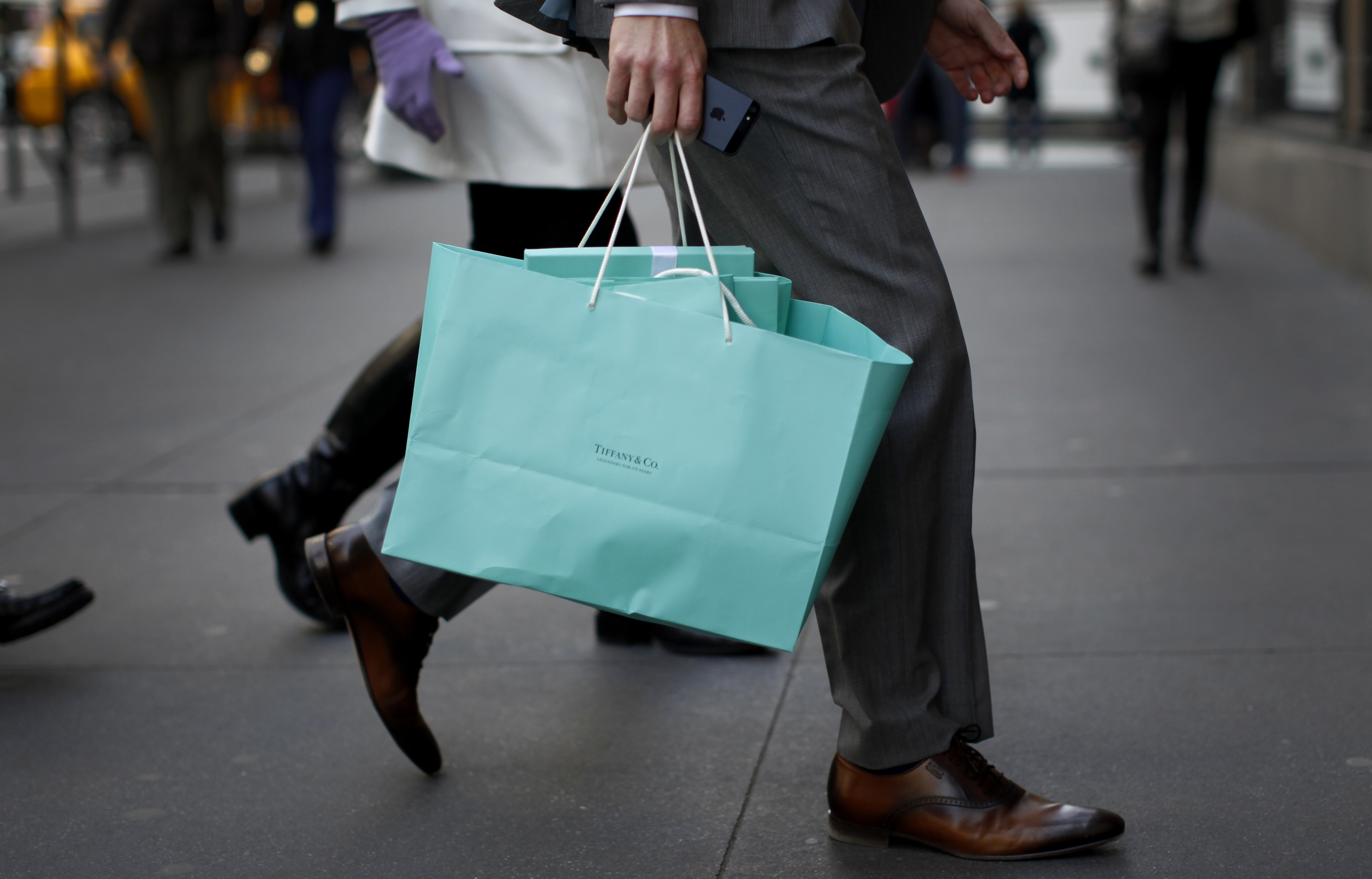 A shopper carries bags from Tiffany &amp; Co. jewelers along 5th Avenue in New York City
