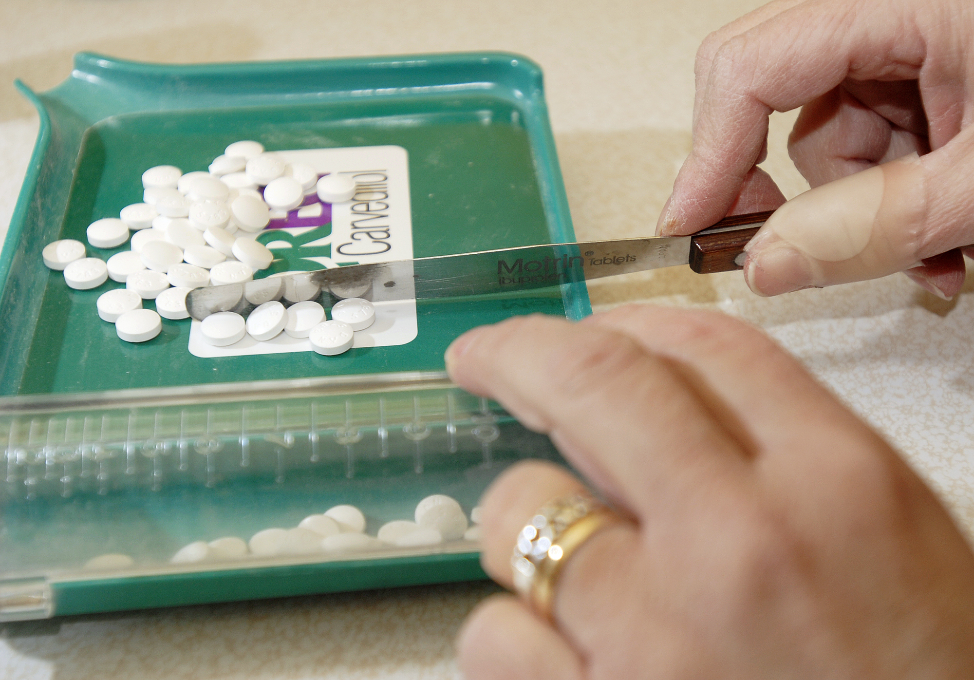 Pharmacy technician Andrea Tibbetts counts out pills to fill an order for generic medications at Por