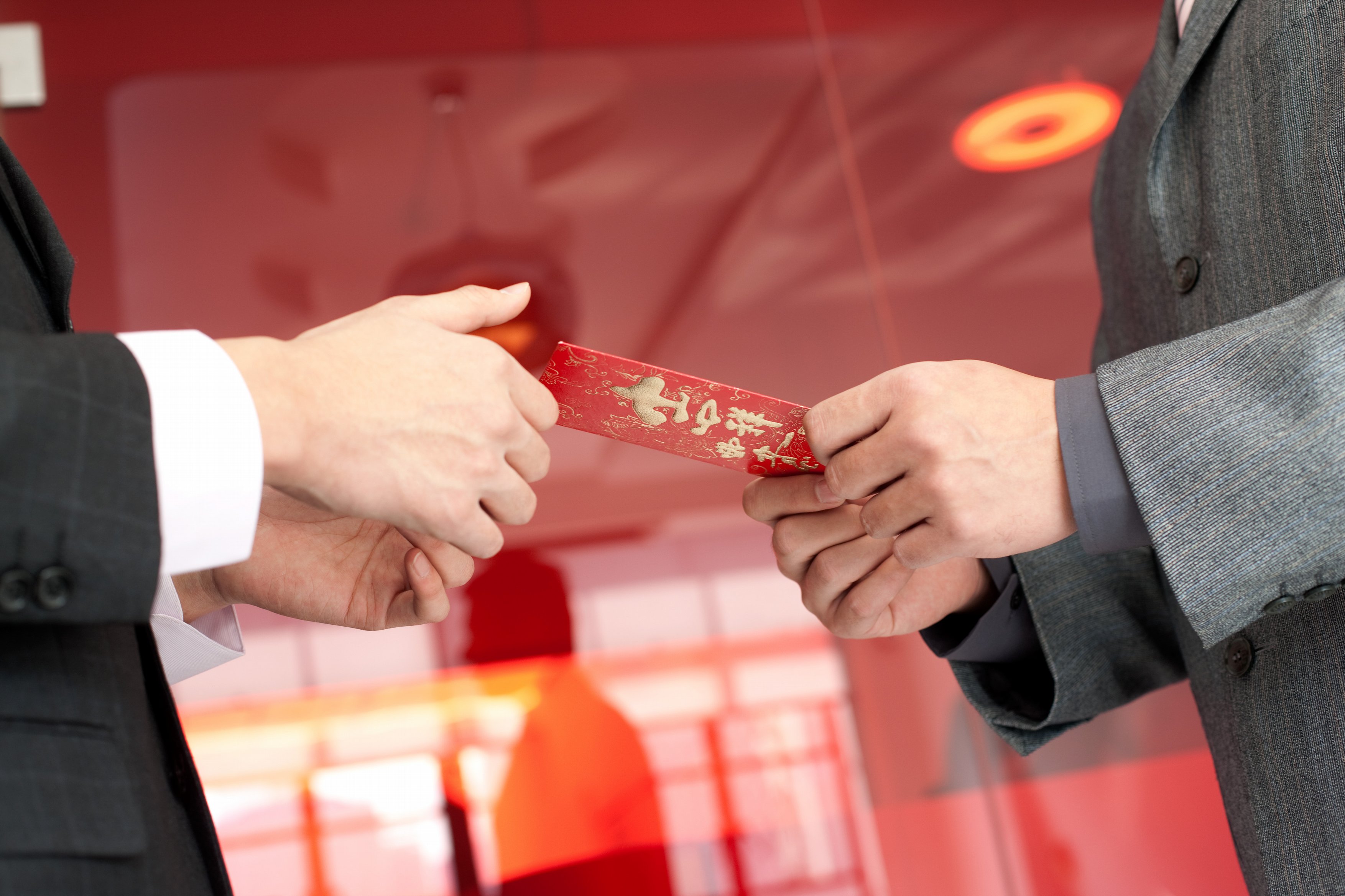 This file photo shows a Chinese man giving the other man Hongbao (a red envelope) with lucky money for Chinese Lunar New Year in Shanghai, China.