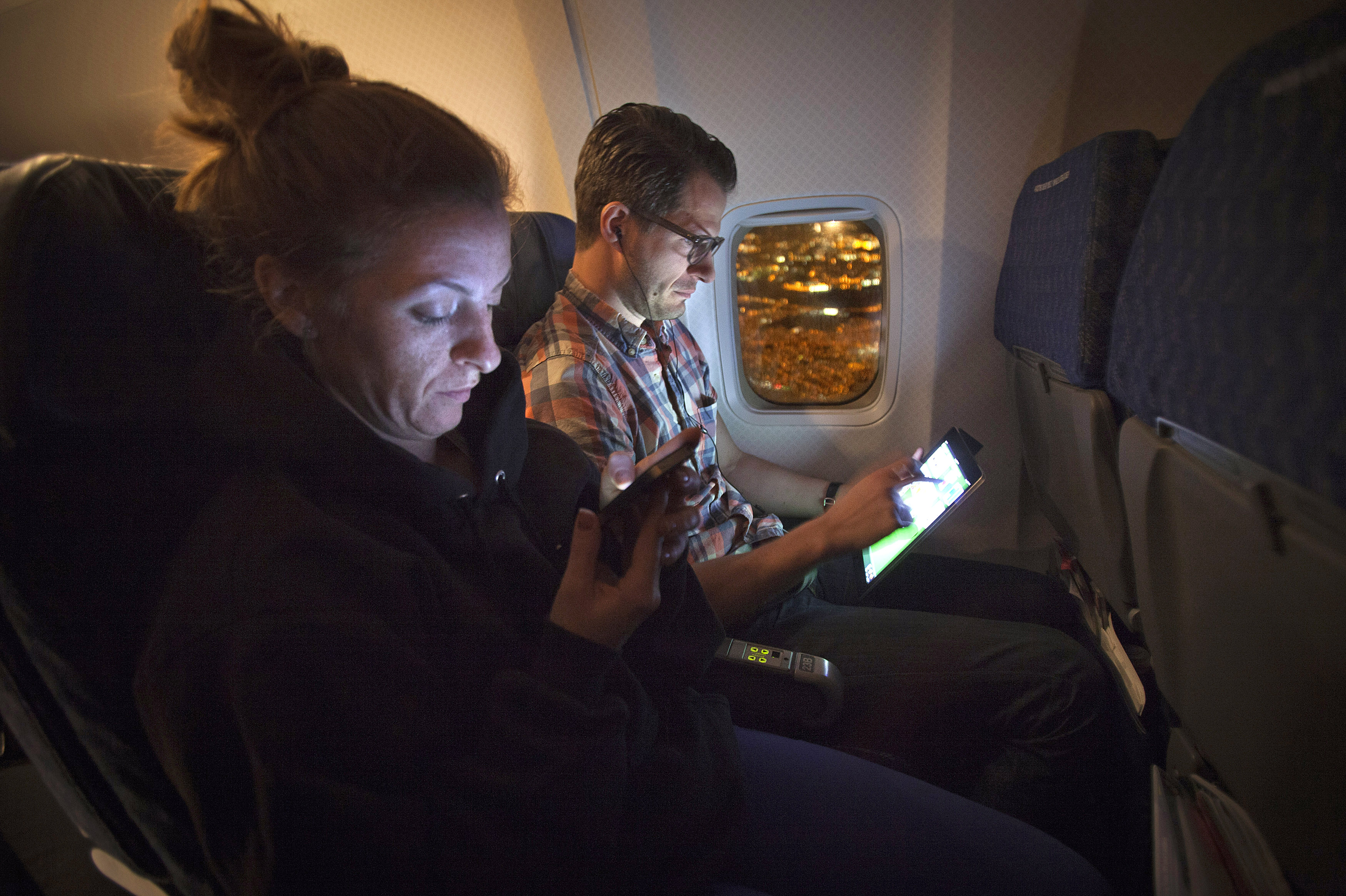 People use their smart devices on an American Airlines airplane, which is equipped with Gogo Inflight Internet service, enroute from Miami to New York