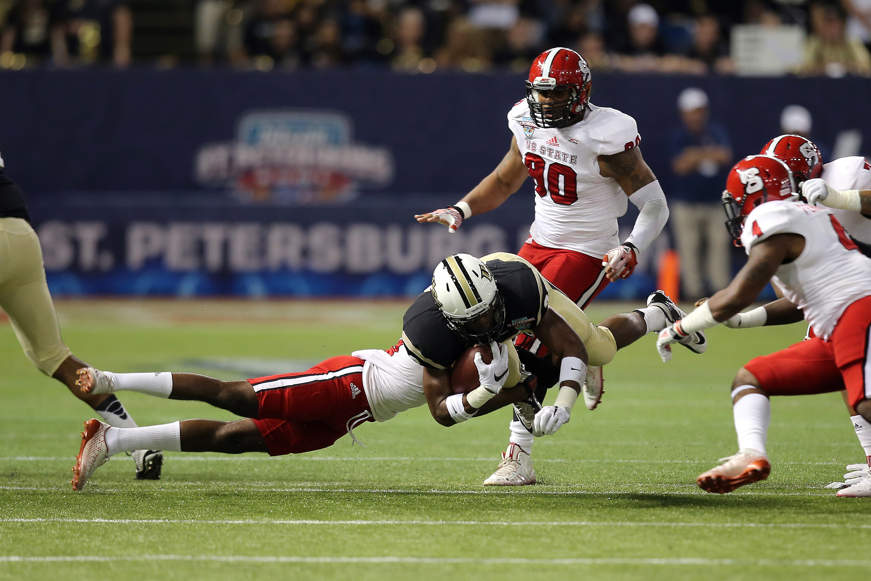 ST PETERSBURG, FL - DECEMBER 26: Rannell Hall #6 of the UCF Knights is tackled is during the NCAA Bitcoin St Petersburg bowl against the North Carolina State Wolfpack at Tropicana Field on December 26, 2014 in St. Petersburg, Florida. (Photo by Alex Menendez/Getty Images)