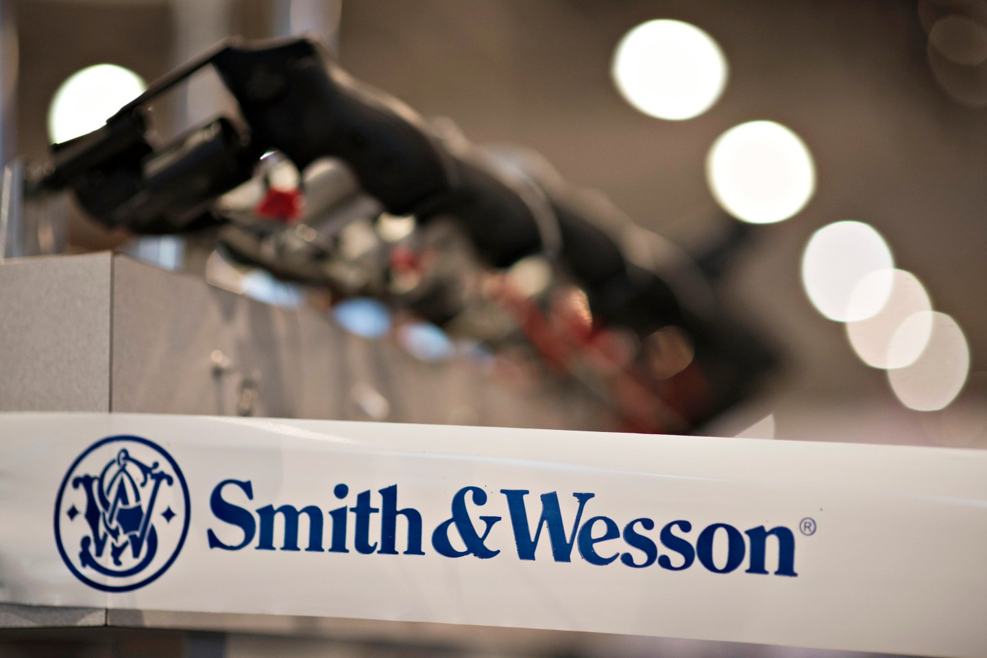 A Smith &amp; Wesson Holding Corp. logo appears on tape  surrounding the company booth on the exhibition floor ahead of the 144th National Rifle Association (NRA) Annual Meetings and Exhibits at the Music City Center in Nashville, Tennessee, U.S., on Thursday, April 9, 2015. Top Republican contenders for their party's 2016 presidential nomination are lining up to speak at the annual NRA event, except New Jersey Governor Chris Christie and Kentucky Senator Rand Paul who were snubbed by the country's largest and most powerful gun lobby. Photographer: Daniel Acker/Bloomberg