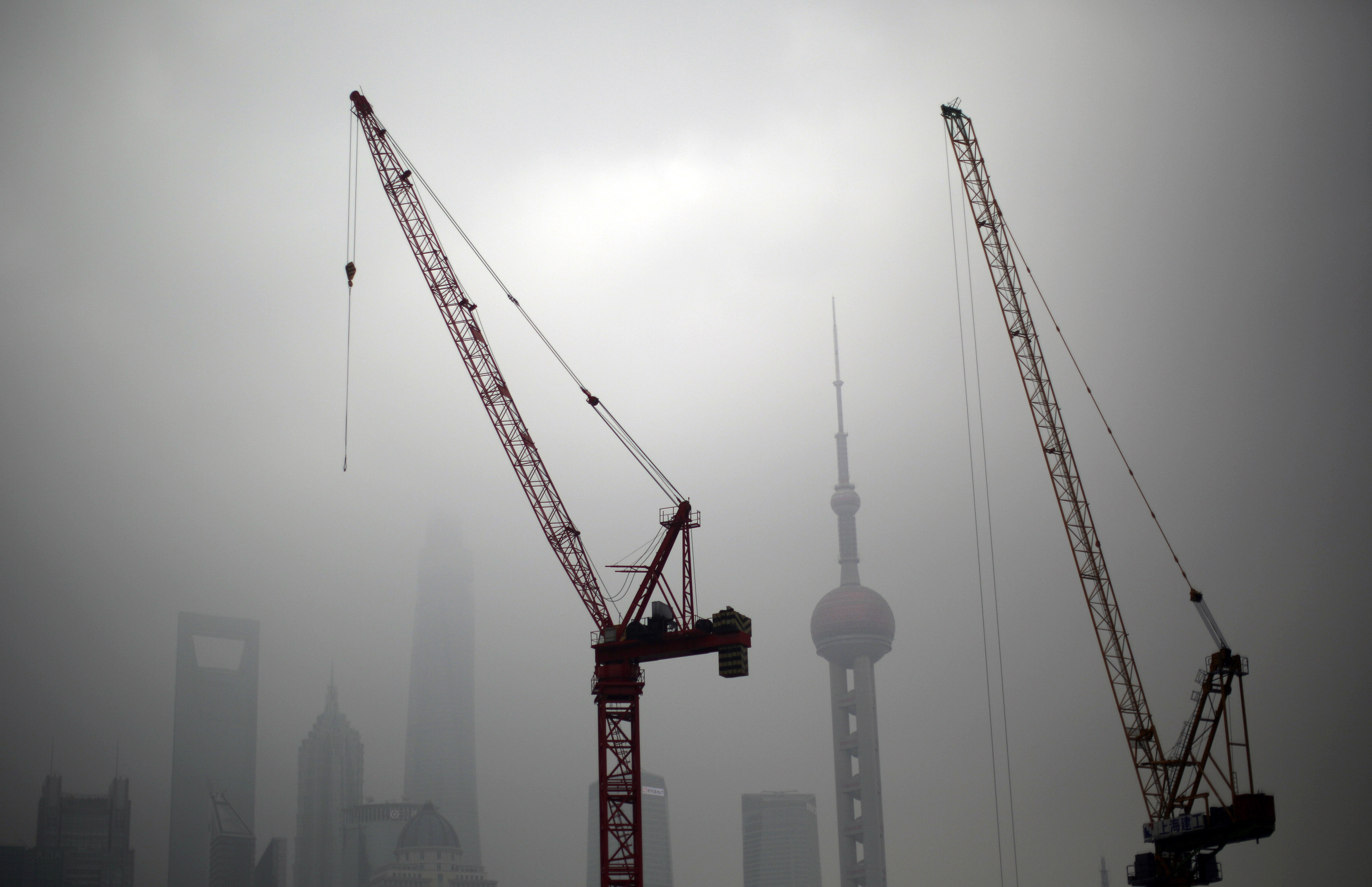 Construction cranes are see near Pudong financial district of Shanghai