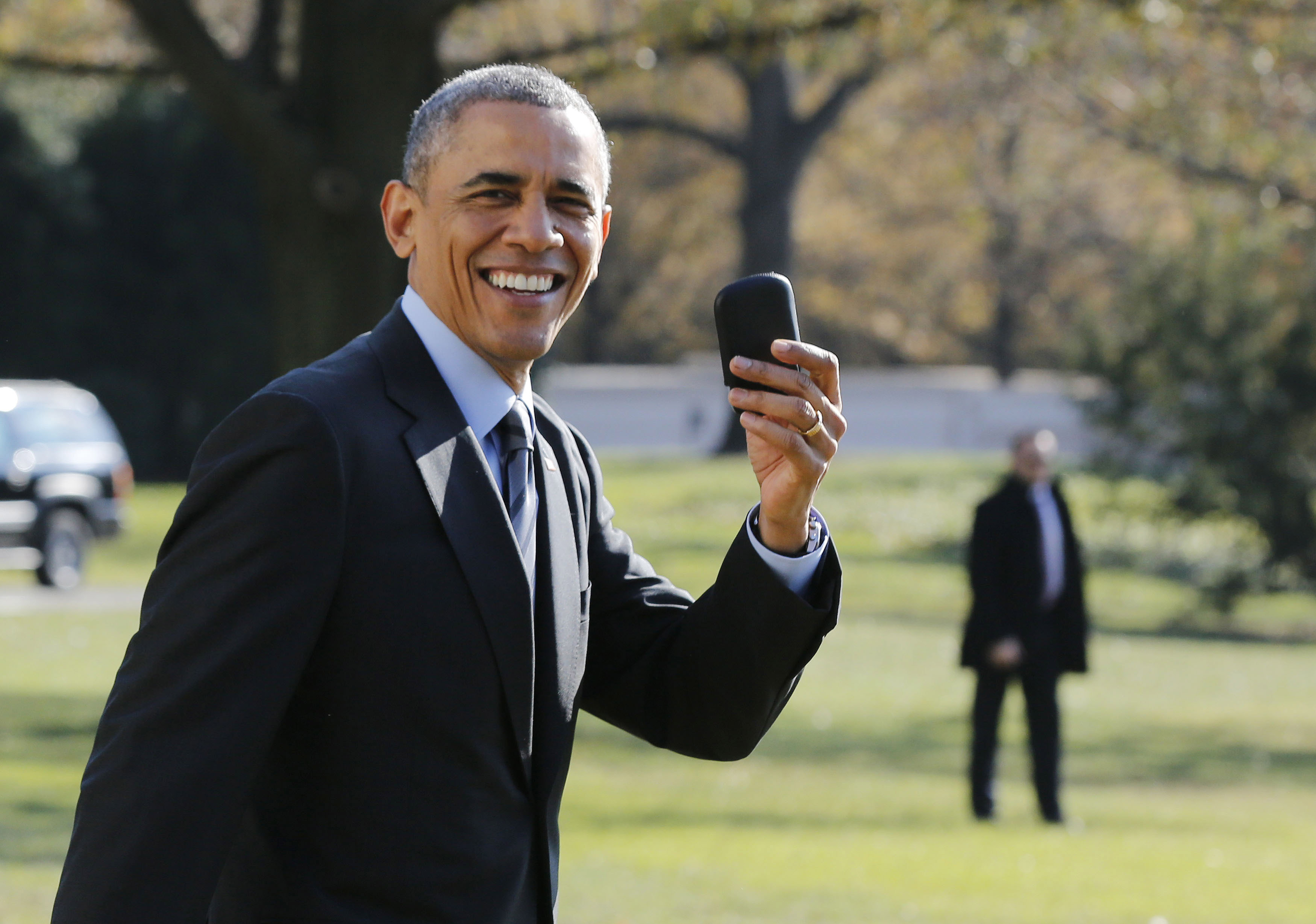 U.S. President Obama holds up his BlackBerry device after he returned inside the White House to retrieve it, after boarding Marine One on the South Lawn of the White House in Washington