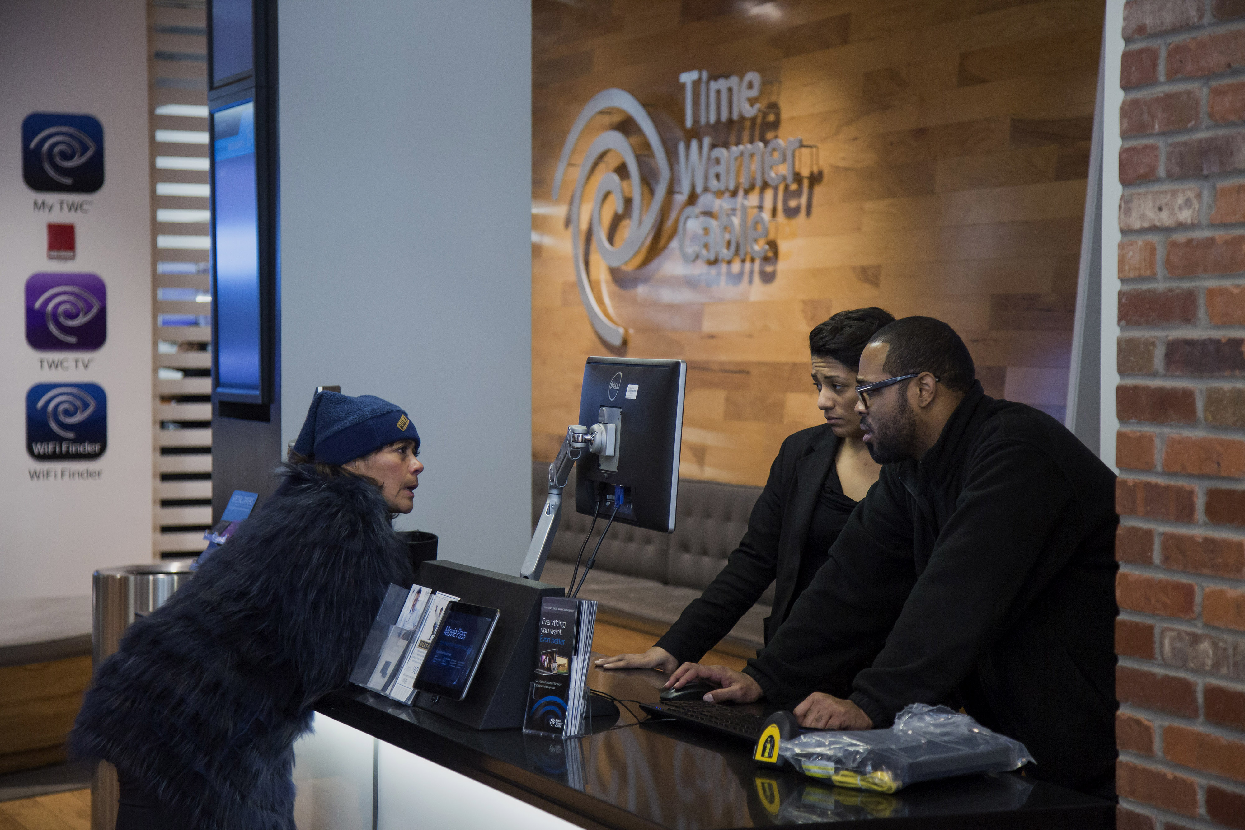 Time Warner Cable Inc. employees helps a customer inside the Time Warner Cable Inc. store in New York, N.Y., U.S., on Wednesday, January 28, 2015. Photographer: Michael Nagle/Bloomberg