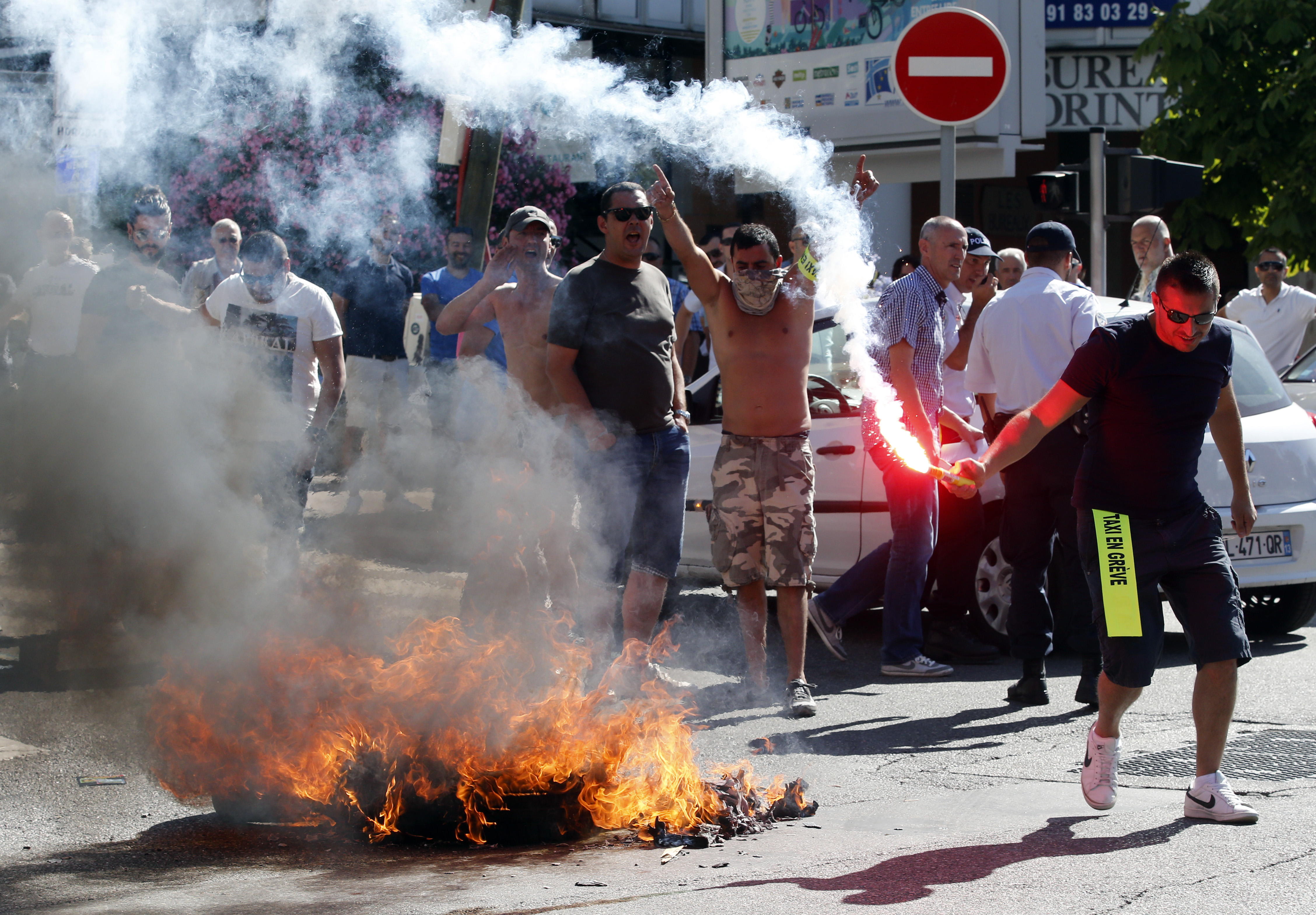 Taxi drivers on strike burn tyres during a national protest against car-sharing service Uber in Marseille