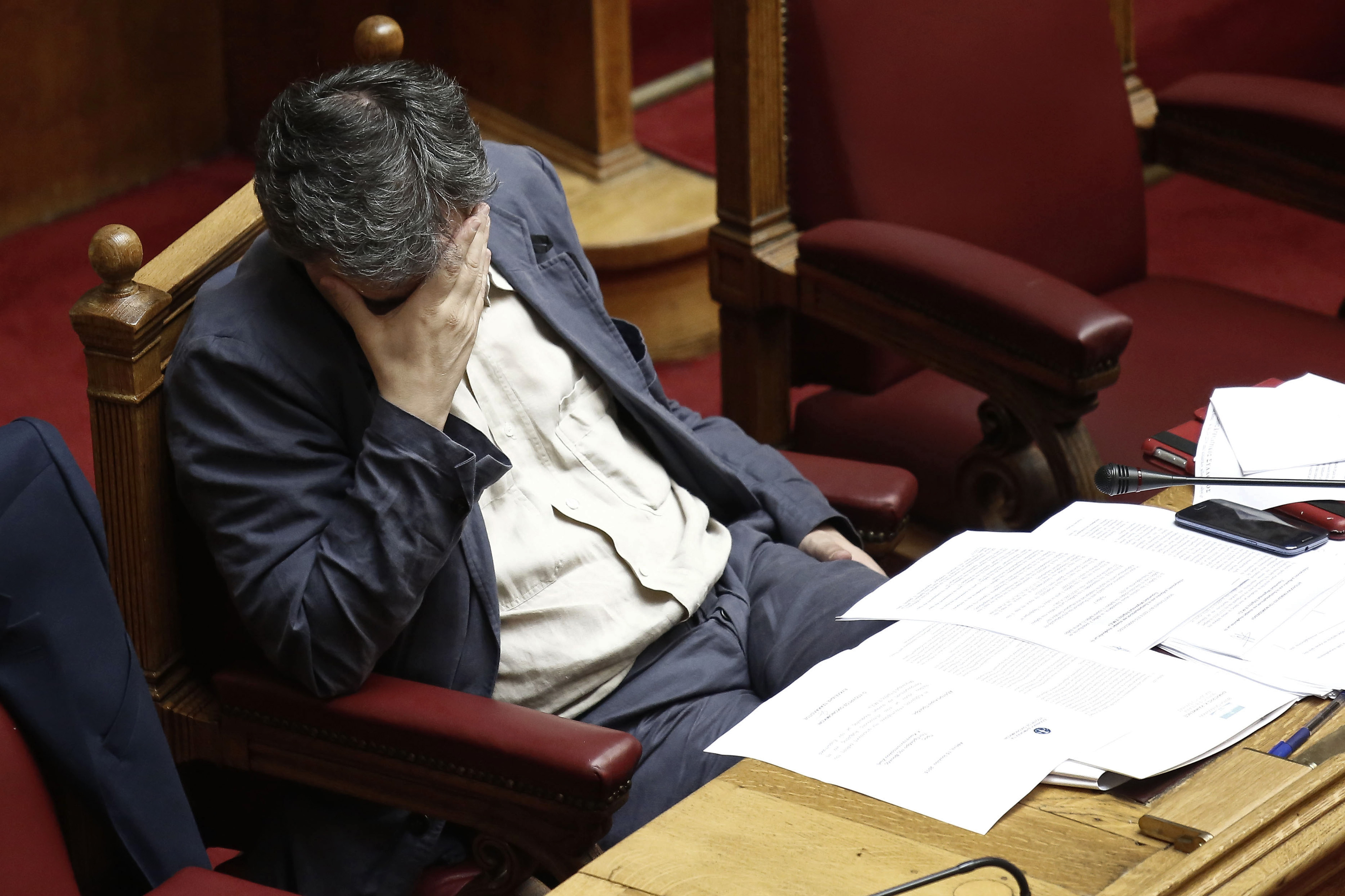 Euclid Tsakalotos, Greece's finance minister, pauses while attending a parliamentary meeting in Athens, Greece, on Wednesday, July 15, 2015. Parliament will vote Wednesday night on the measures Greece's creditors demanded as a condition for aid as capital controls ravage an economy that has already shrunk by a quarter since 2009. Photographer: Kostas Tsironis/Bloomberg *** Local Caption *** Euclid Tsakalotos