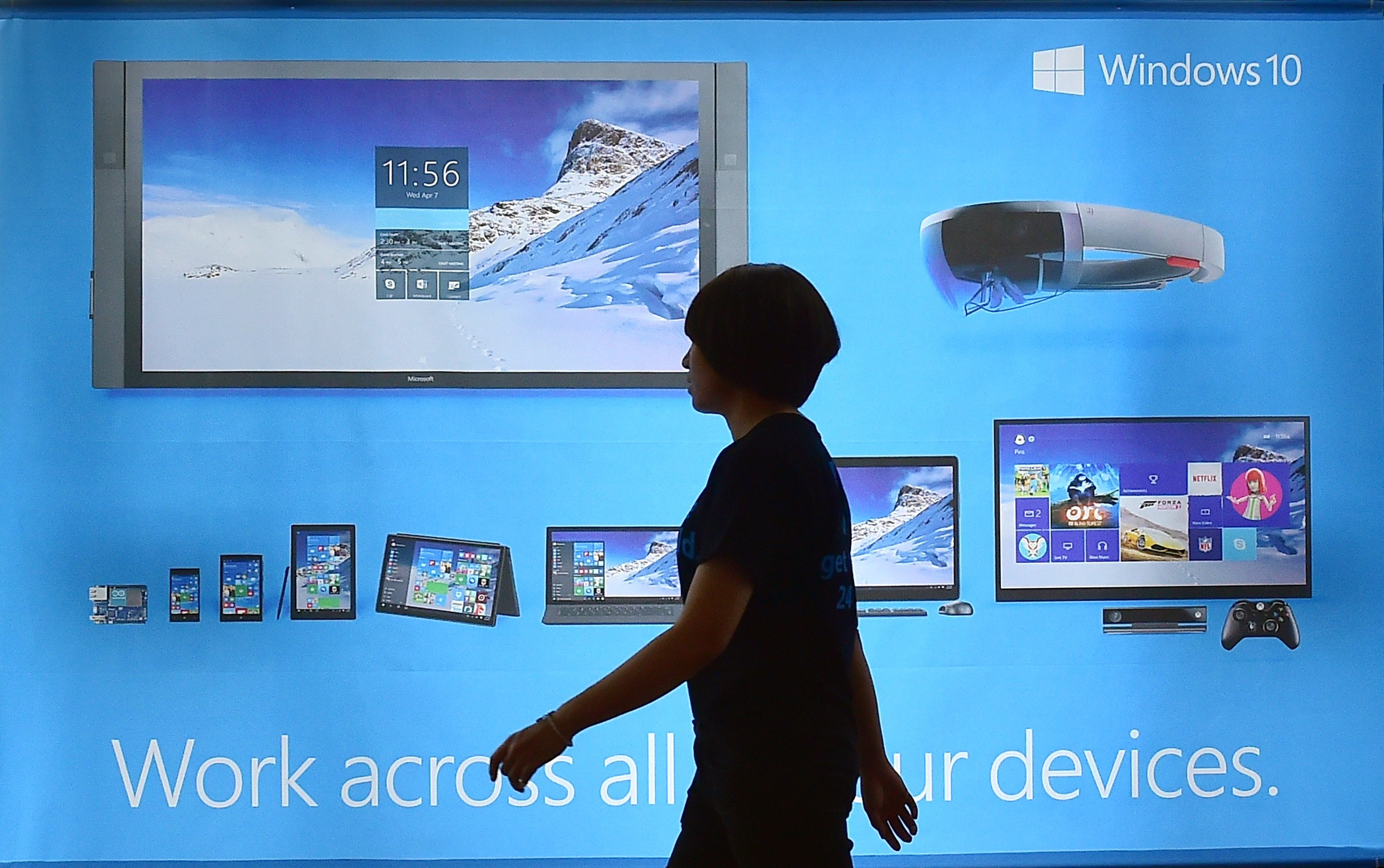 A woman walks past a billboard for Windows 10, the latest operating system from US software giant Microsoft.