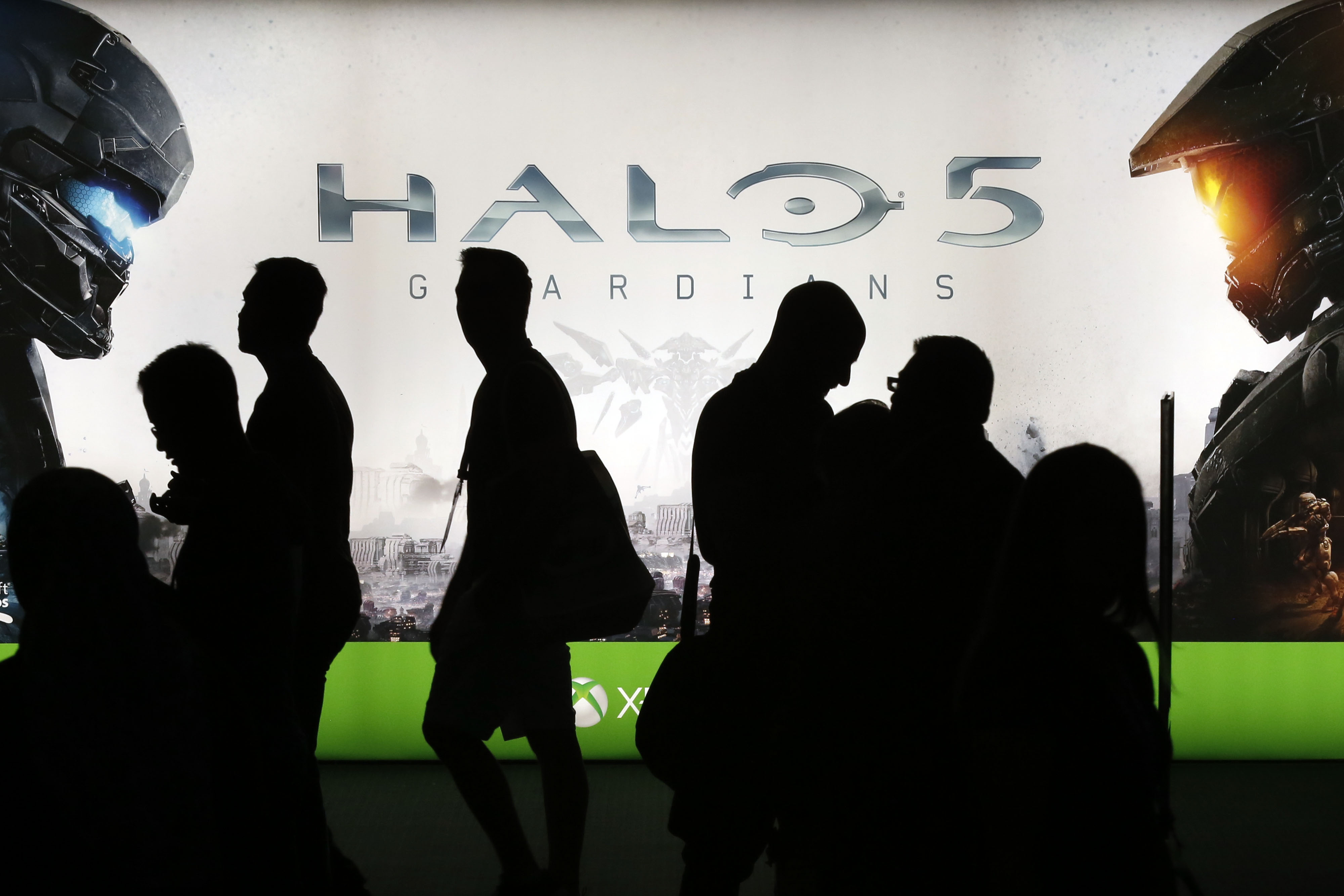 People walk past signage for Microsoft's Halo 5: Guardians game.