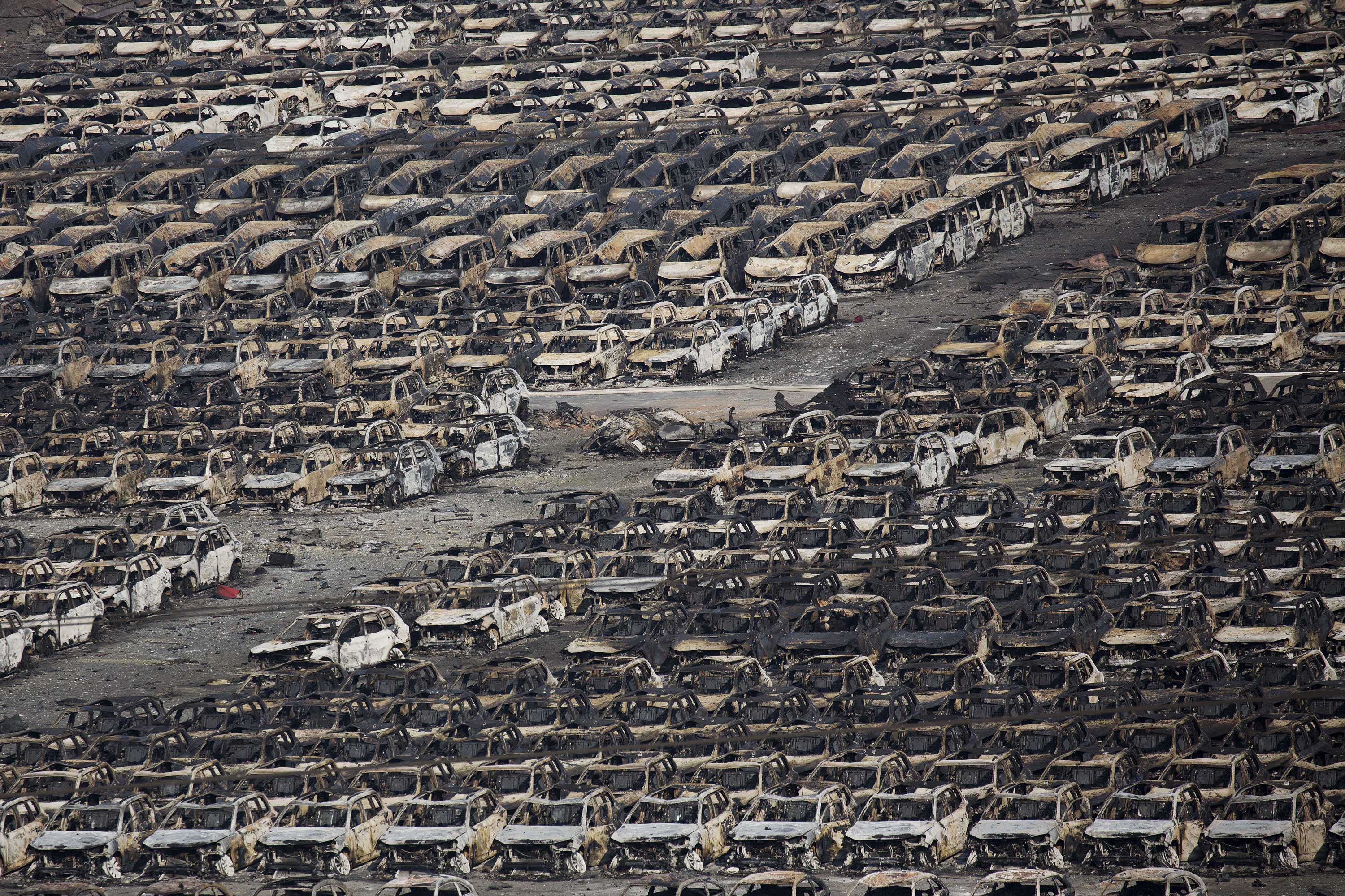 Burnt cars are seen near the site of the explosions at the Binhai new district, Tianjin
