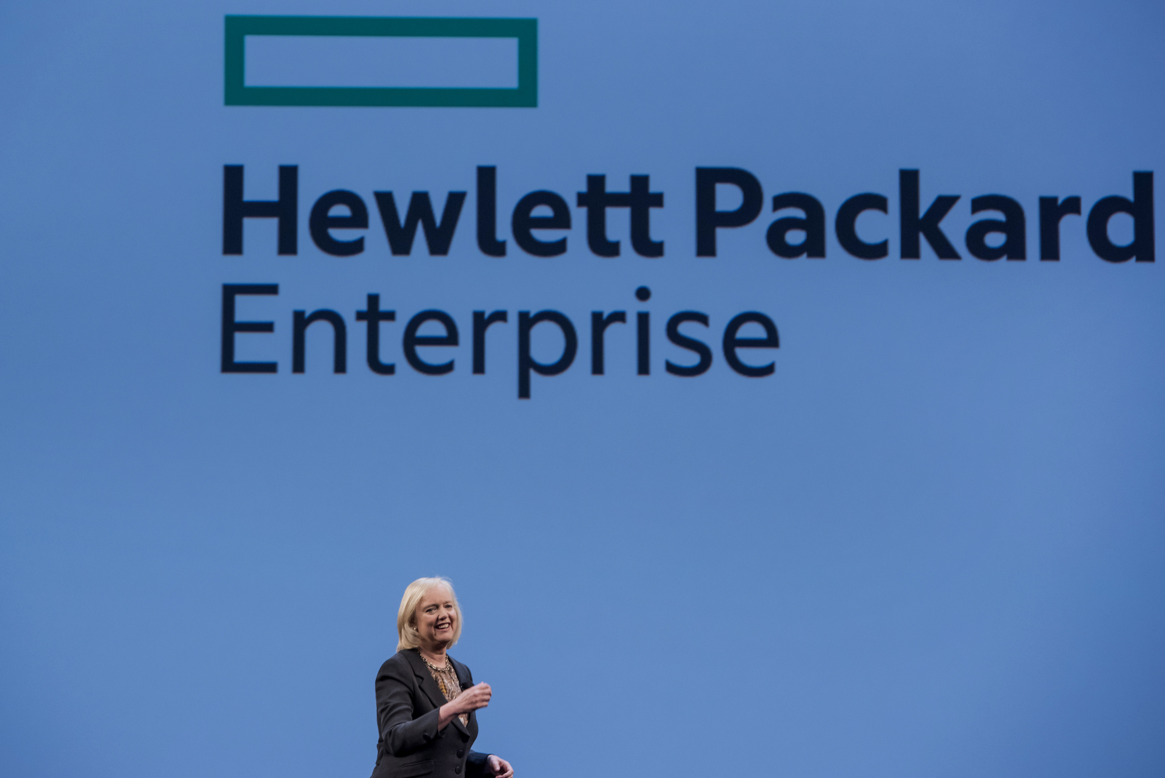 Meg Whitman, chief executive officer of Hewlett-Packard Co., speaks with the new Hewlett Packard Enterprise logo on the screen, during the HP Discover 2015 conference in Las Vegas, Nevada, U.S., on Tuesday, June 2, 2015. Hewlett-Packard Co. reported fiscal second-quarter profit that exceeded analysts' estimates as corporate spending on servers picked up ahead of the computer maker's planned separation into two companies. Photographer: David Paul Morris *** Local Caption *** Meg Whitman