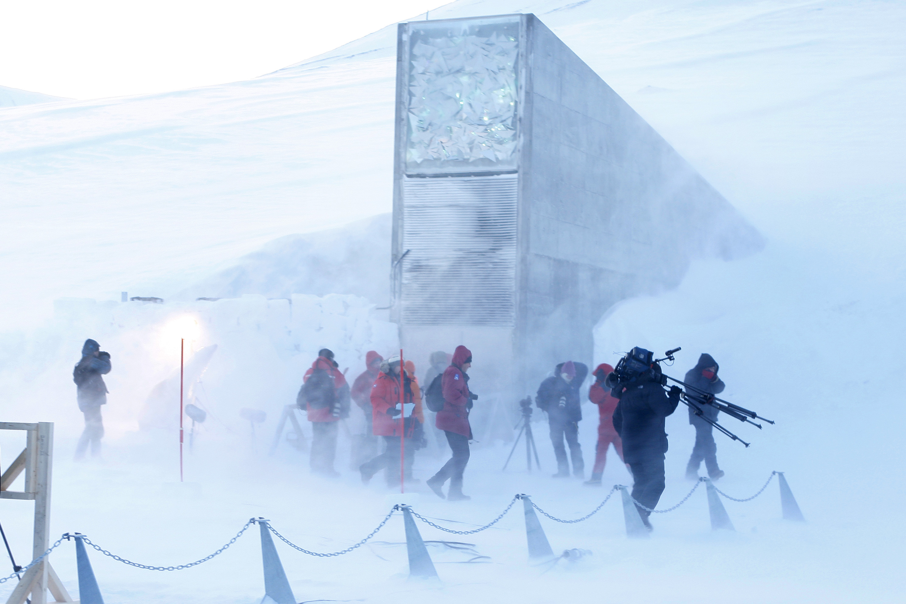 Journalists and cameramen walk under a g