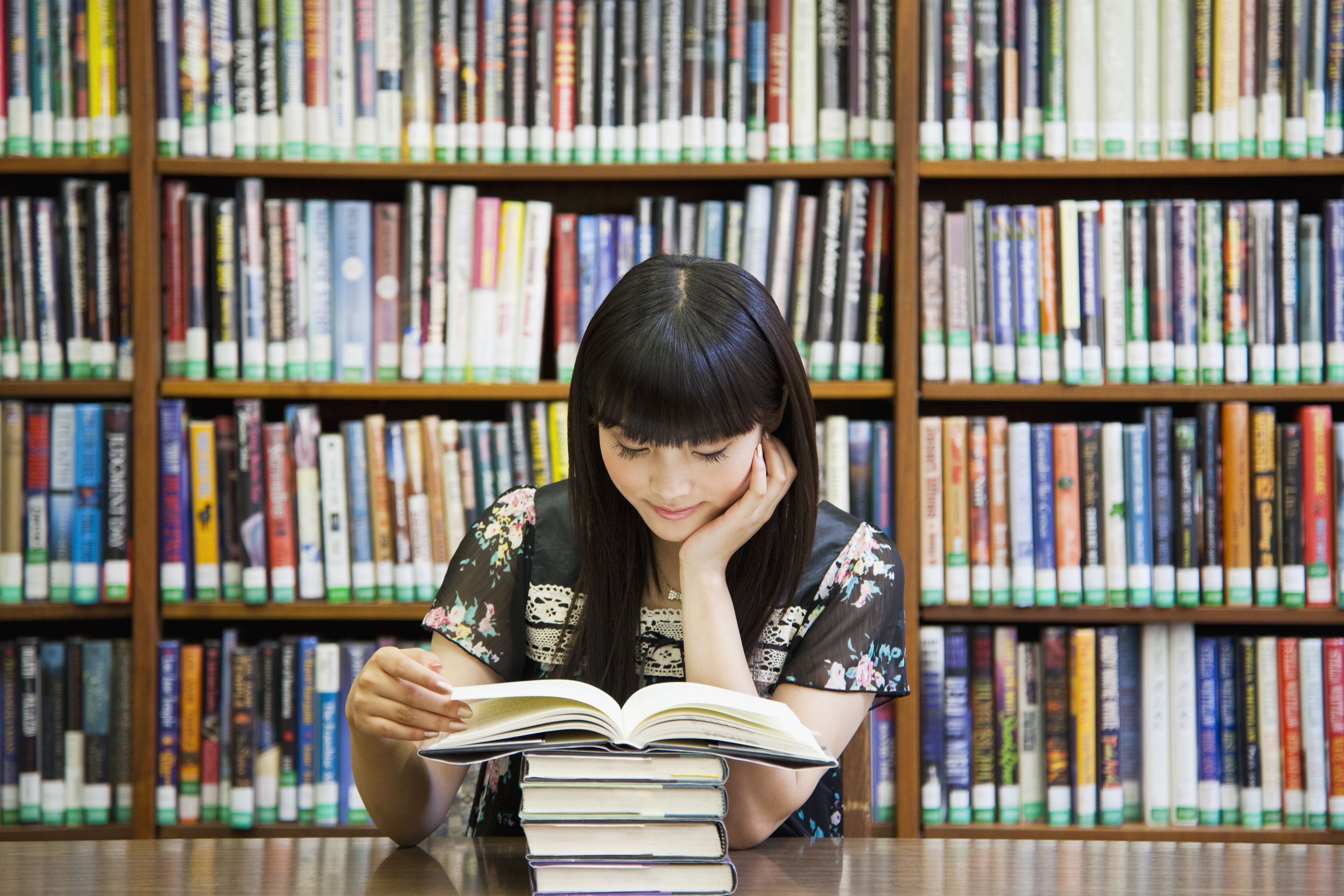 Asian woman reading book in library