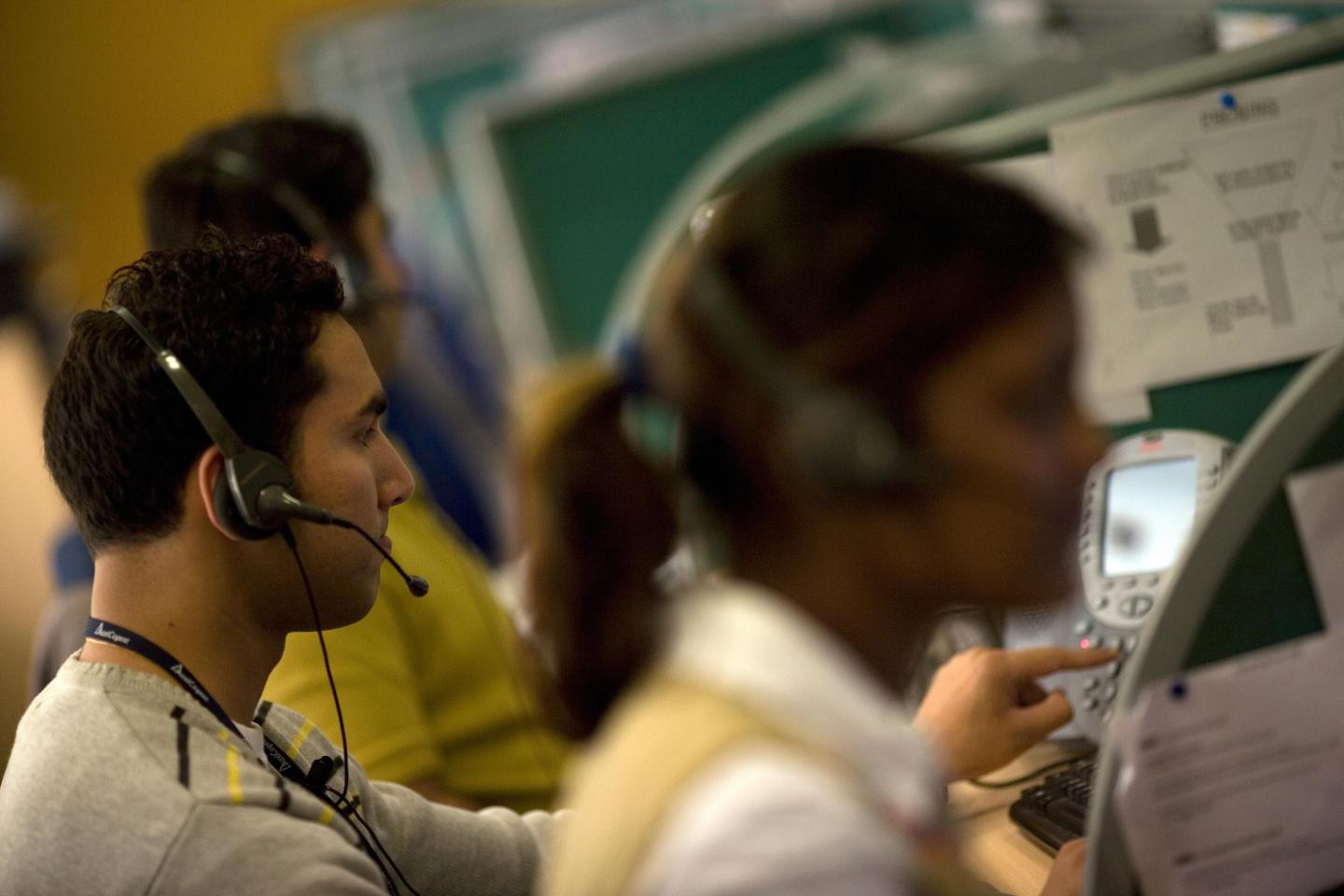 Indian workers answer telephone calls at