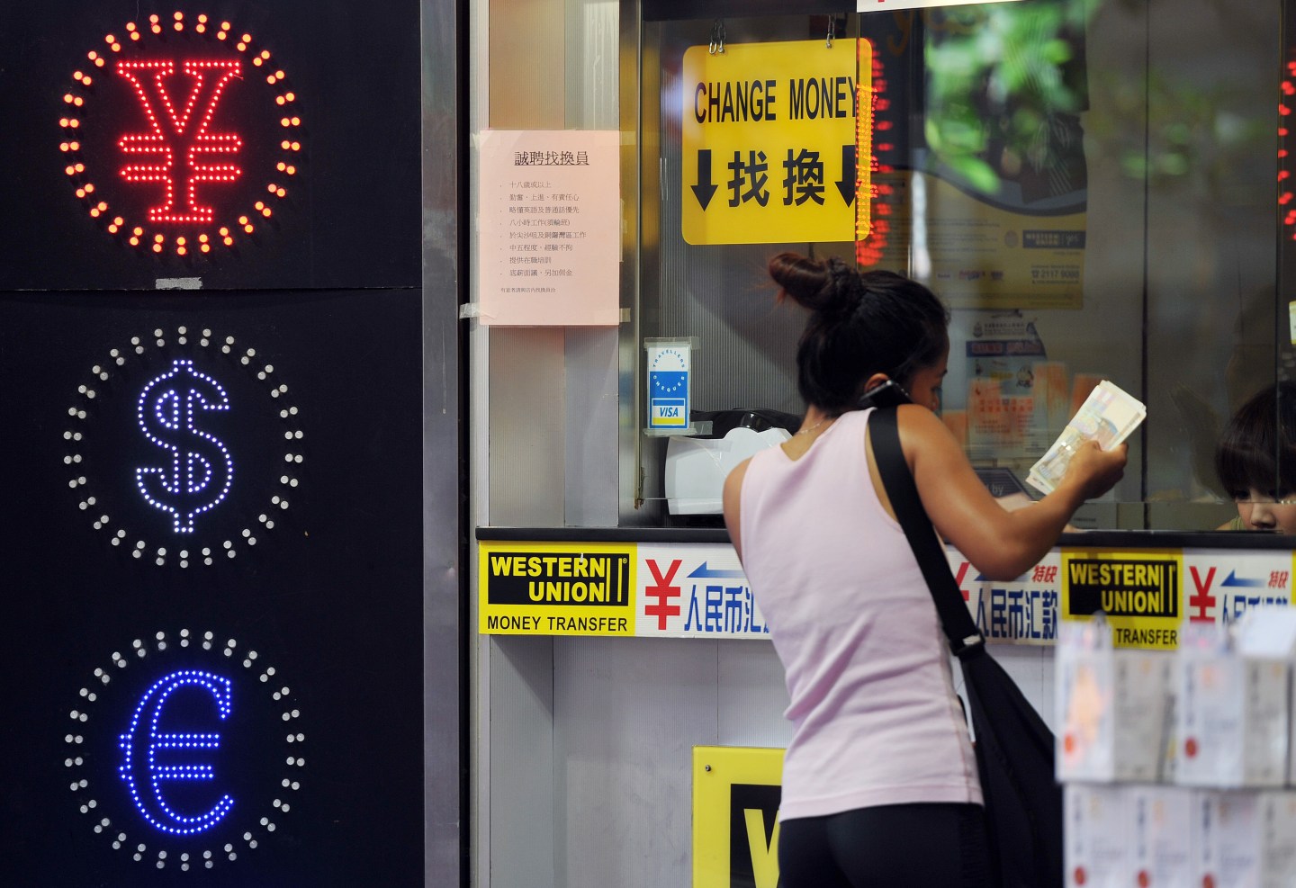 A woman exchanges money at a currency exchange shop in Hong Kong.