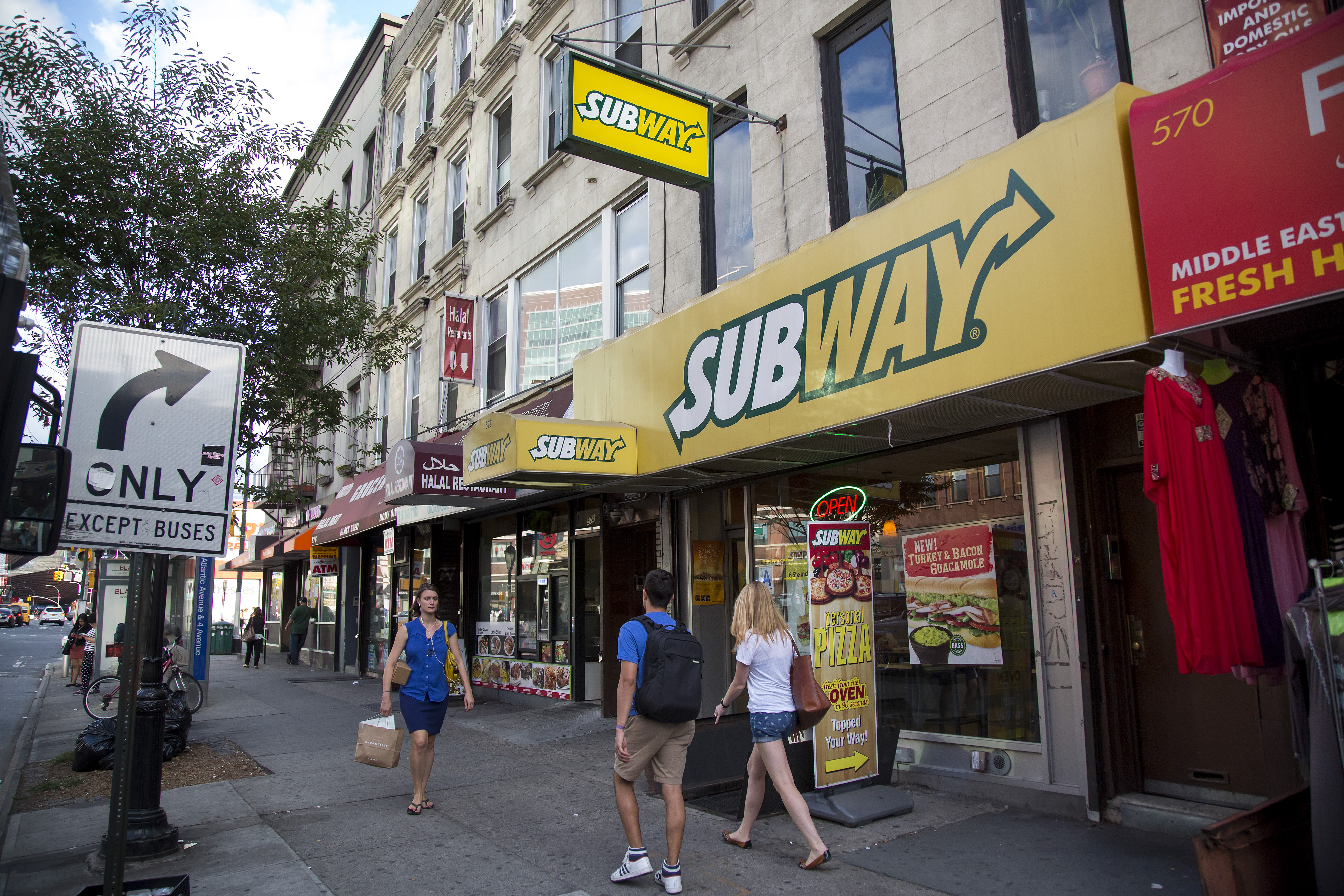 Pedestrians pass a Subway restaurant on Atlantic Avenue in Brooklyn, U.S., on Thursday, August 27, 2015. Photographer: Michael Nagle/Bloomberg
