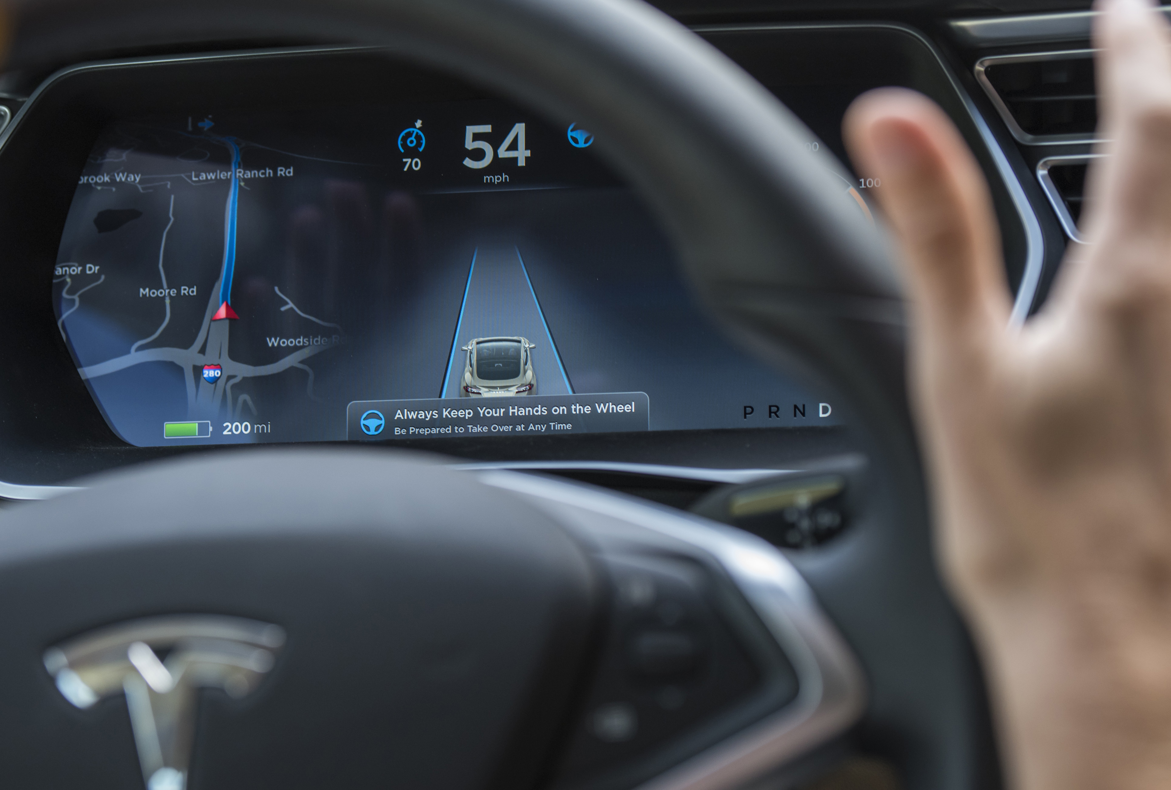 A member of the media test drives a Tesla Motors Inc., Model S car equipped with Autopilot at the Tesla Motors Inc. headquarters in Palo Alto, California, U.S., on Wednesday, Oct. 14, 2015. Tesla Motors Inc. will begin rolling out the first version of its highly anticipated “autopilot” features to owners of its all-electric Model S sedan Thursday. Autopilot is a step toward the vision of autonomous or self-driving cars, and includes features like automatic lane changing and the ability of the Model S to parallel park for you. Photographer: David Paul Morris/Bloomberg