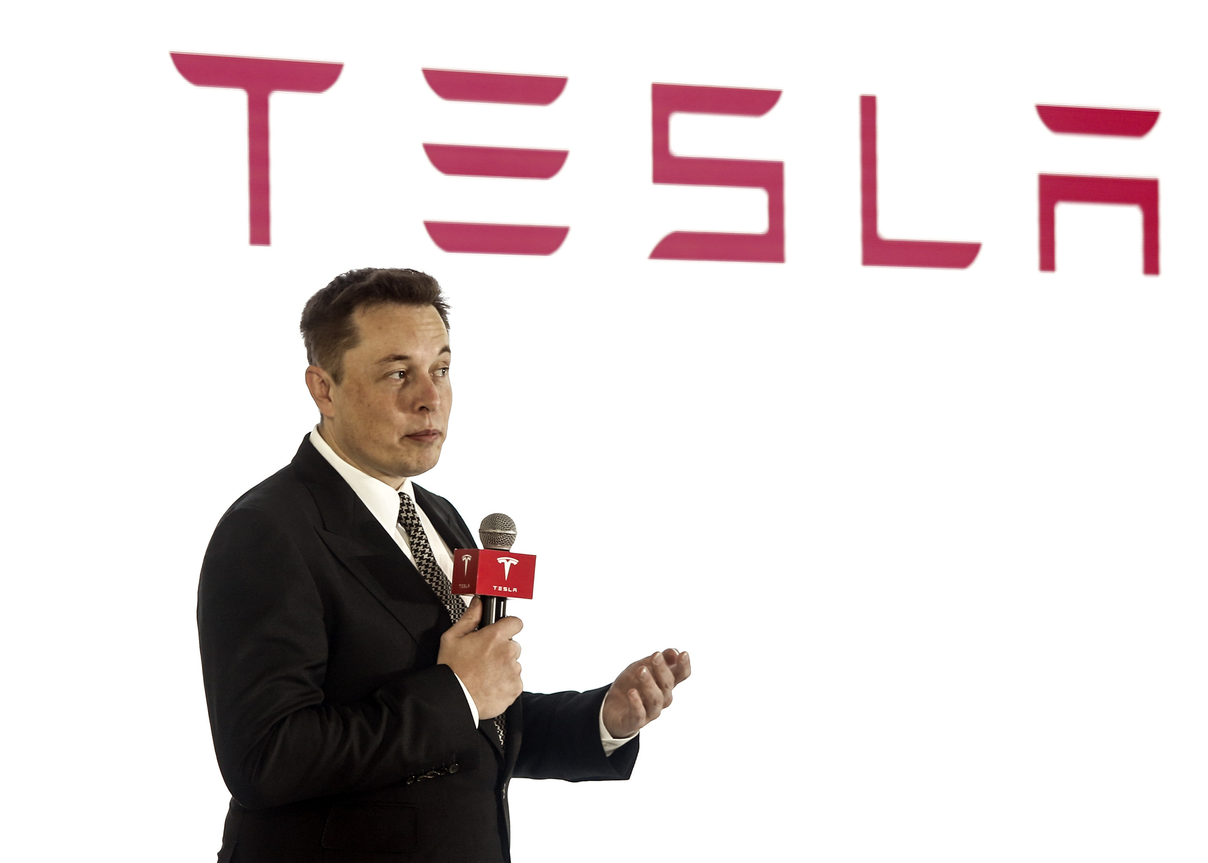 BEIJING, CHINA - OCTOBER 23: (CHINA OUT) Elon Musk, Chairman, CEO and Product Architect of Tesla Motors, addresses a press conference to declare that the Tesla Motors releases v7.0 System in China on a limited basis for its Model S, which will enable self-driving features such as Autosteer for a select group of beta testers on October 23, 2015 in Beijing, China. The v7.0 system includes Autosteer, a new Autopilot feature. While it's not absolutely self-driving and the driver still need to hold the steering wheel and be mindful of road conditions and surrounding traffic when using Autosteer. When set to the new Autosteer mode, graphics on the driver's display will show the path the Model S is following, post the current speed limit and indicate if a car is in front of the Tesla. (Photo by ChinaFotoPress)***_***