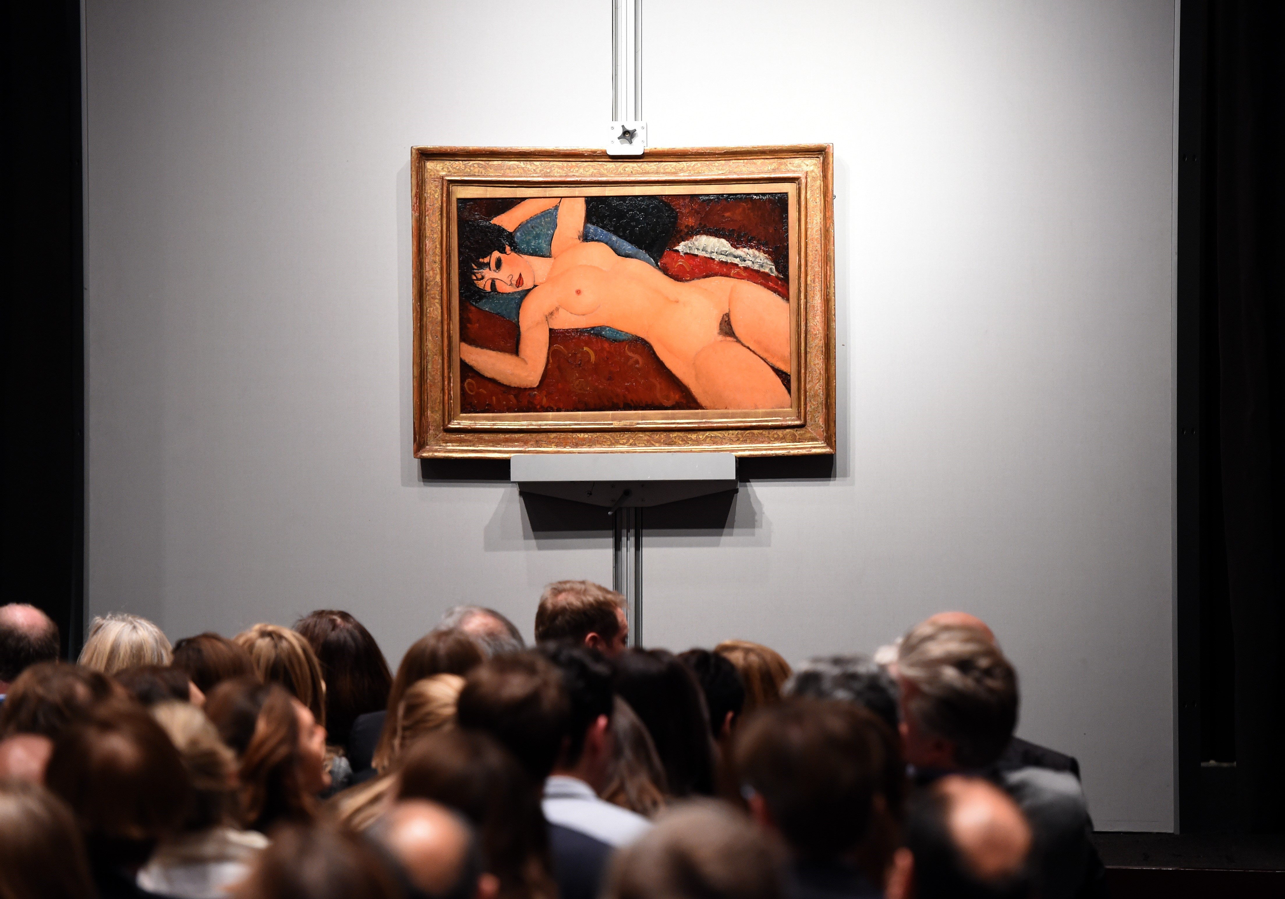 Crowds sit in front of Amedeo Modigliani's "Nu couche" during the "Artist Muse: A Curated Evening Sale" November 9, 2015 at Christie's New York  November 9, 2015.  The painting sold for USD170,405,000. AFP PHOTO / TIMOTHY A. CLARY        (Photo credit should read TIMOTHY A. CLARY/AFP/Getty Images)