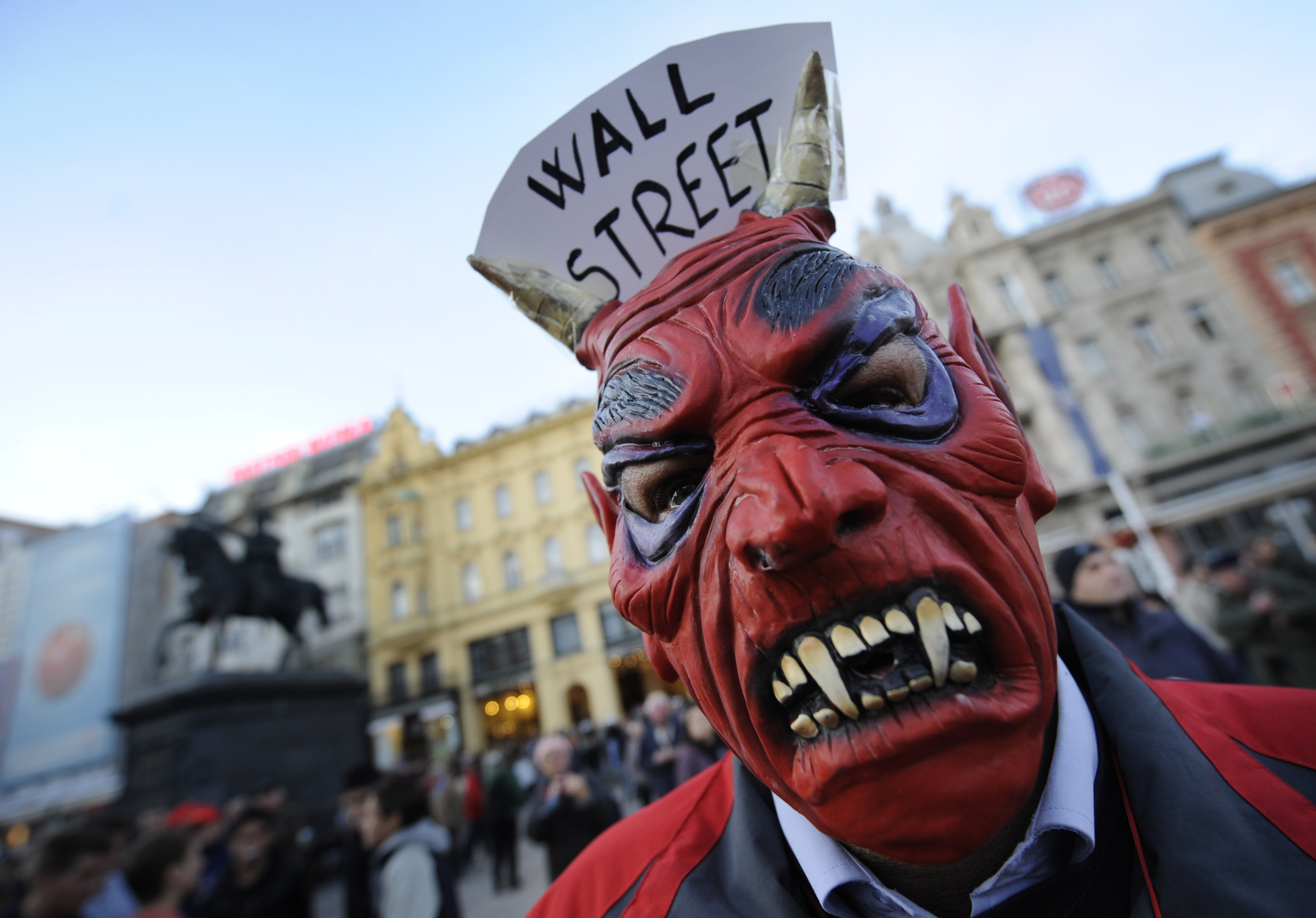 A protester wears a vampire mask with "W