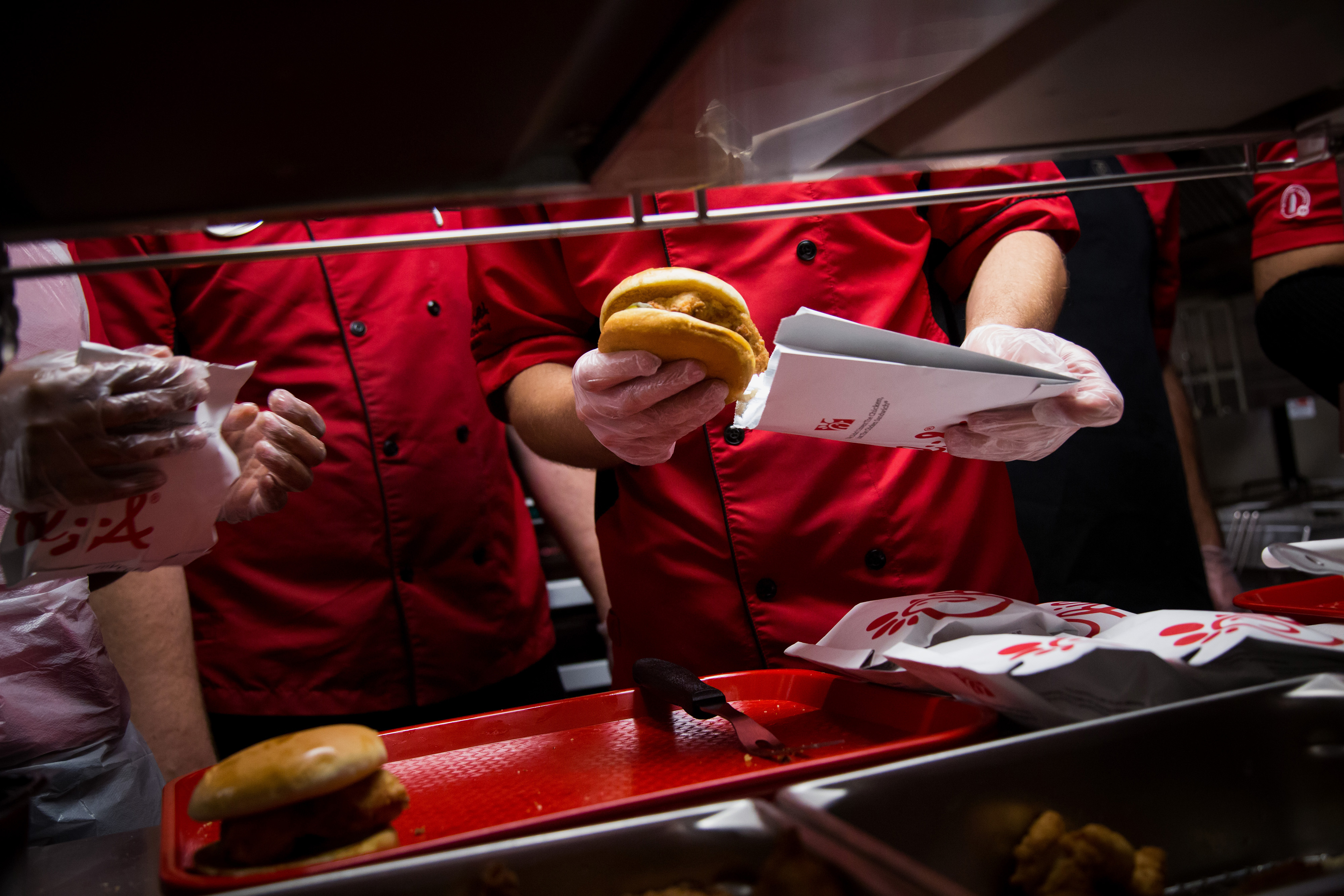 Chick-fil-A Inc. employees prepares chicken sandwiches for guests attending a friends and family event ahead of it's grand opening in New York, U.S., on Friday, October 2, 2015. Photographer: Michael Nagle/Bloomberg