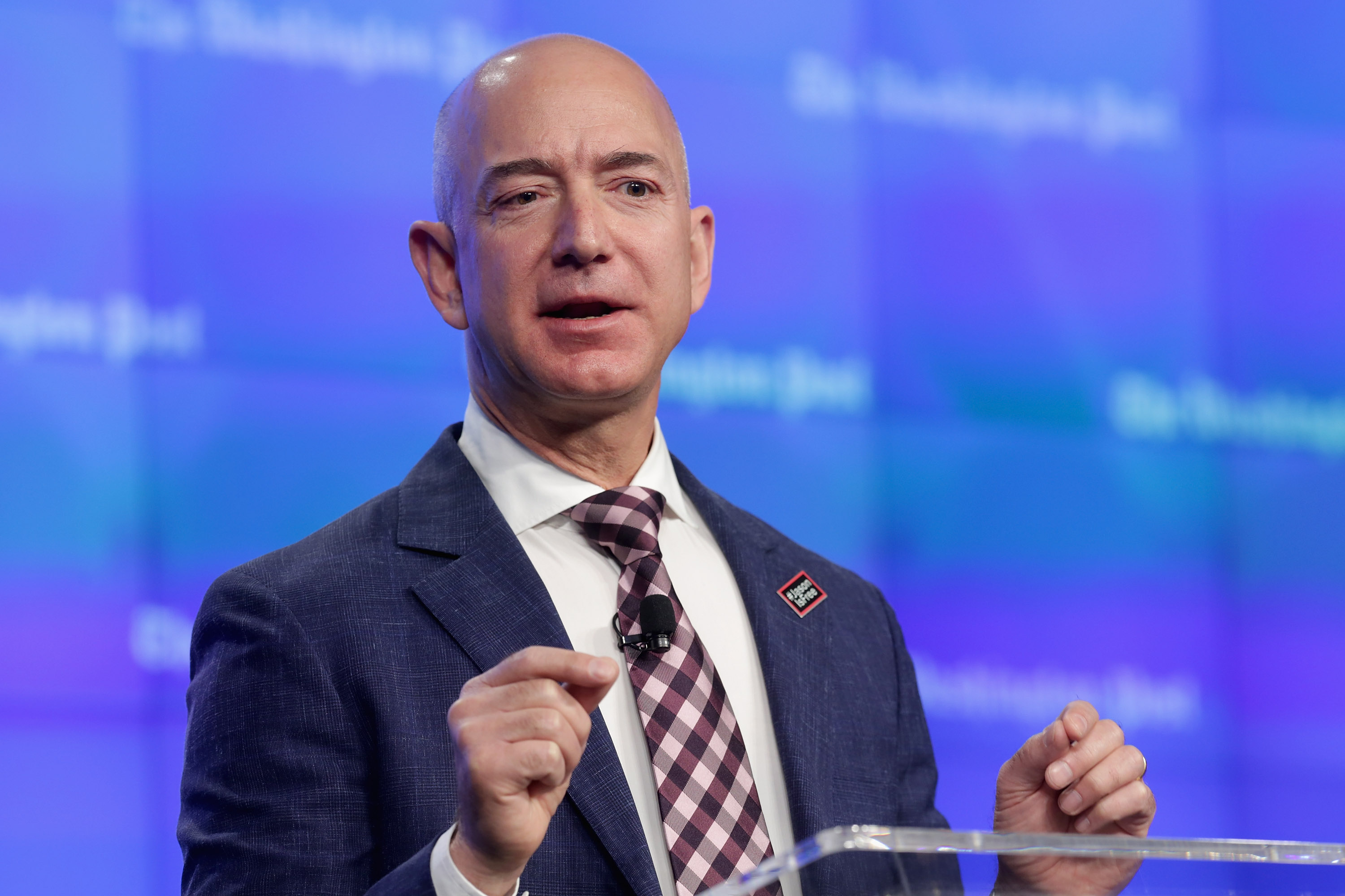 Amazon founder and Washington Post owner Jeff Bezos and U.S. Secretary of State John Kerry deliver remarks during the opening ceremony of the newspaper's new location January 28, 2016 in Washington, DC.
