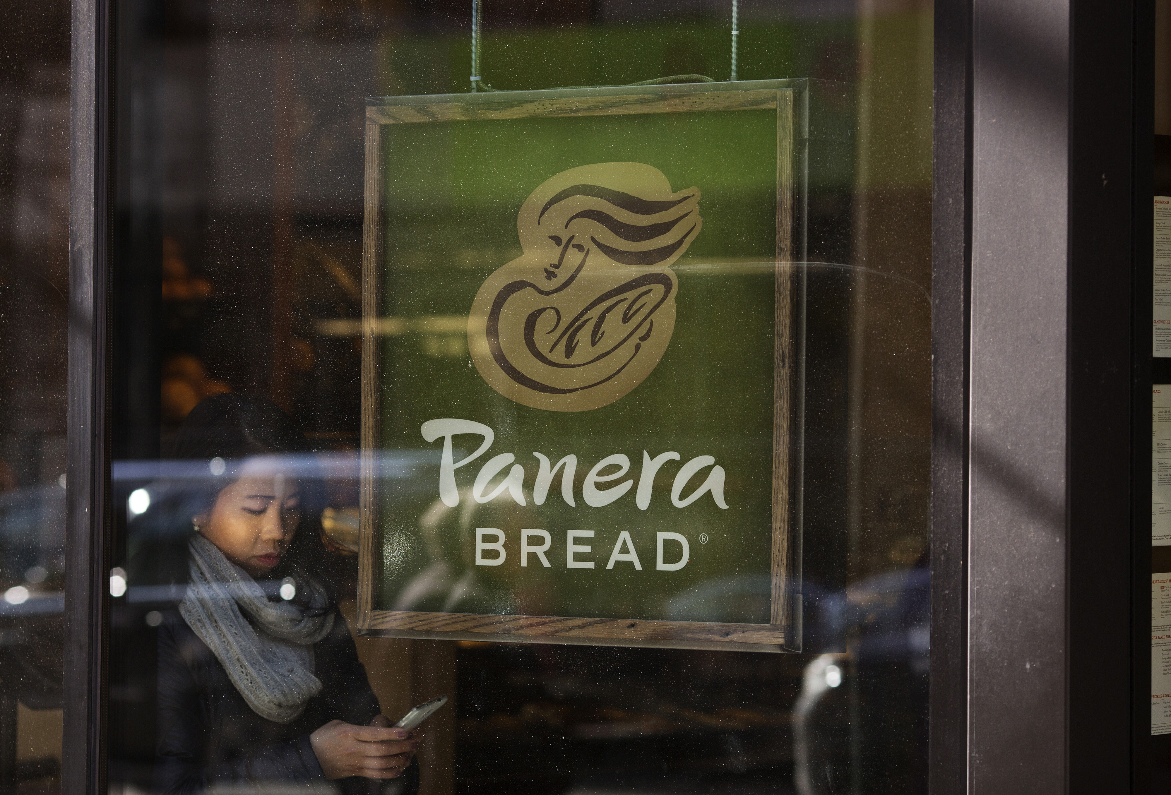 Pedestrians walk by a Panera Bread restaurant in Midtown Manhattan, New York, NY, Tuesday, February 10, 2015.