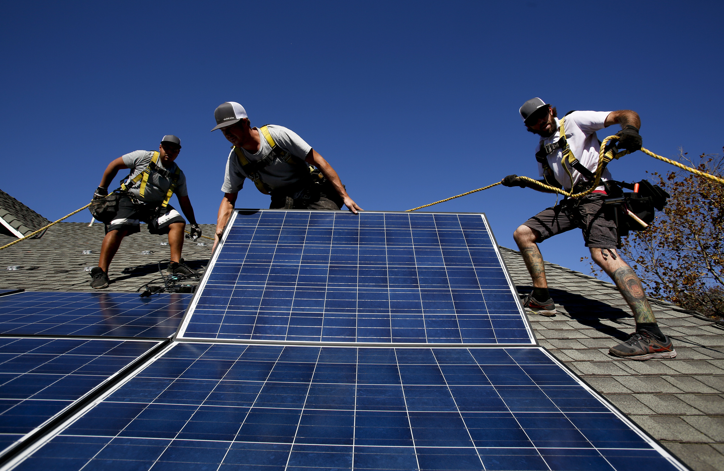Rogelio Mora (CQ), left, Tyler Smith, center, and Randy Murray, right, workers from vivint.solar in