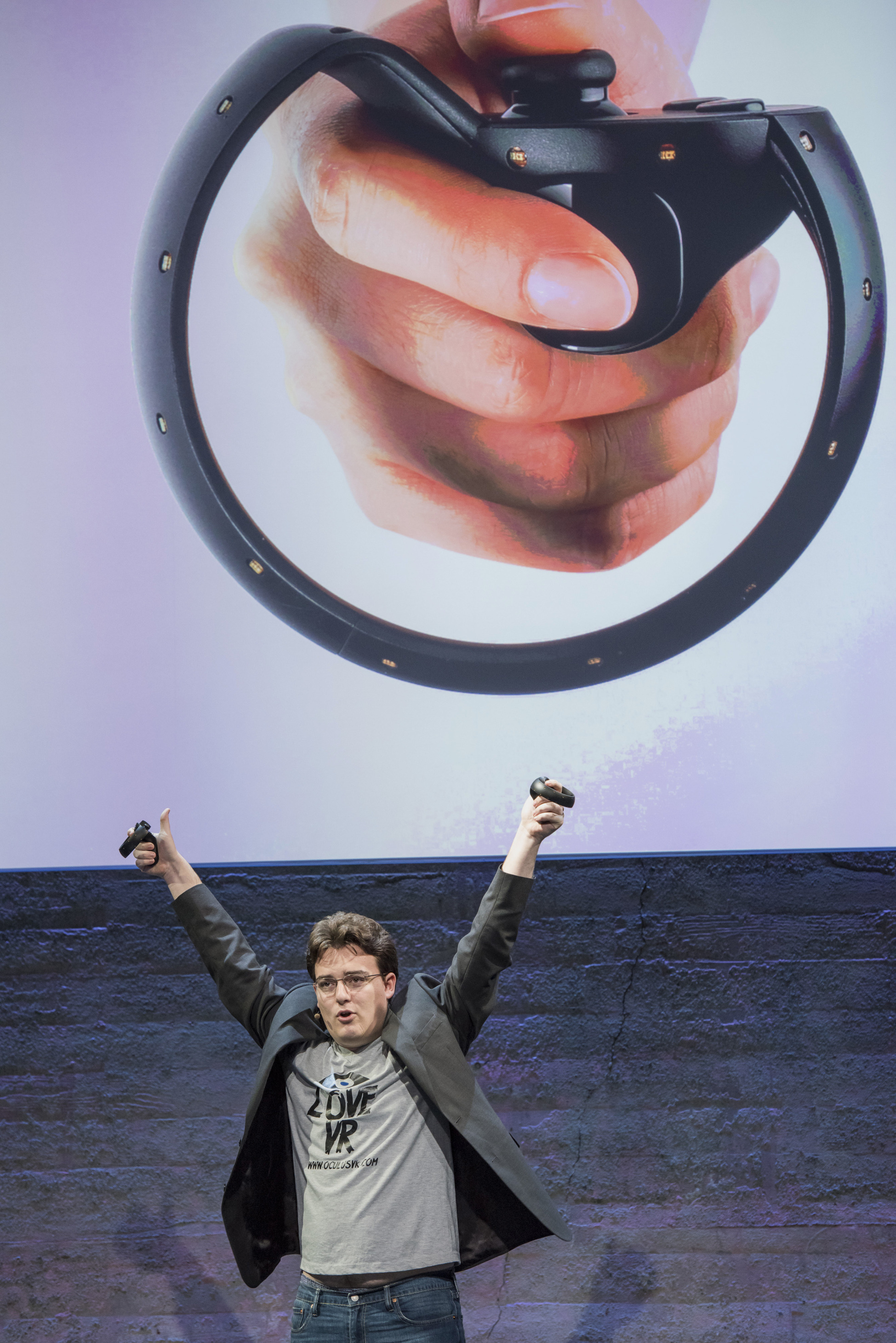 Palmer Luckey, co-founder of Oculus VR. Inc. and creator of the Oculus Rift, holds up the Oculus Touch controller as he speaks during the Oculus VR Inc. "Step Into The Rift" event in San Francisco, California, U.S., on Thursday, June 11, 2015. Facebook Inc.'s Oculus virtual-reality headsets will work with Microsoft Corp.'s Windows 10 and use the software maker's wireless Xbox game controller. Photographer: David Paul Morris/Bloomberg *** Local Caption *** Palmer Luckey