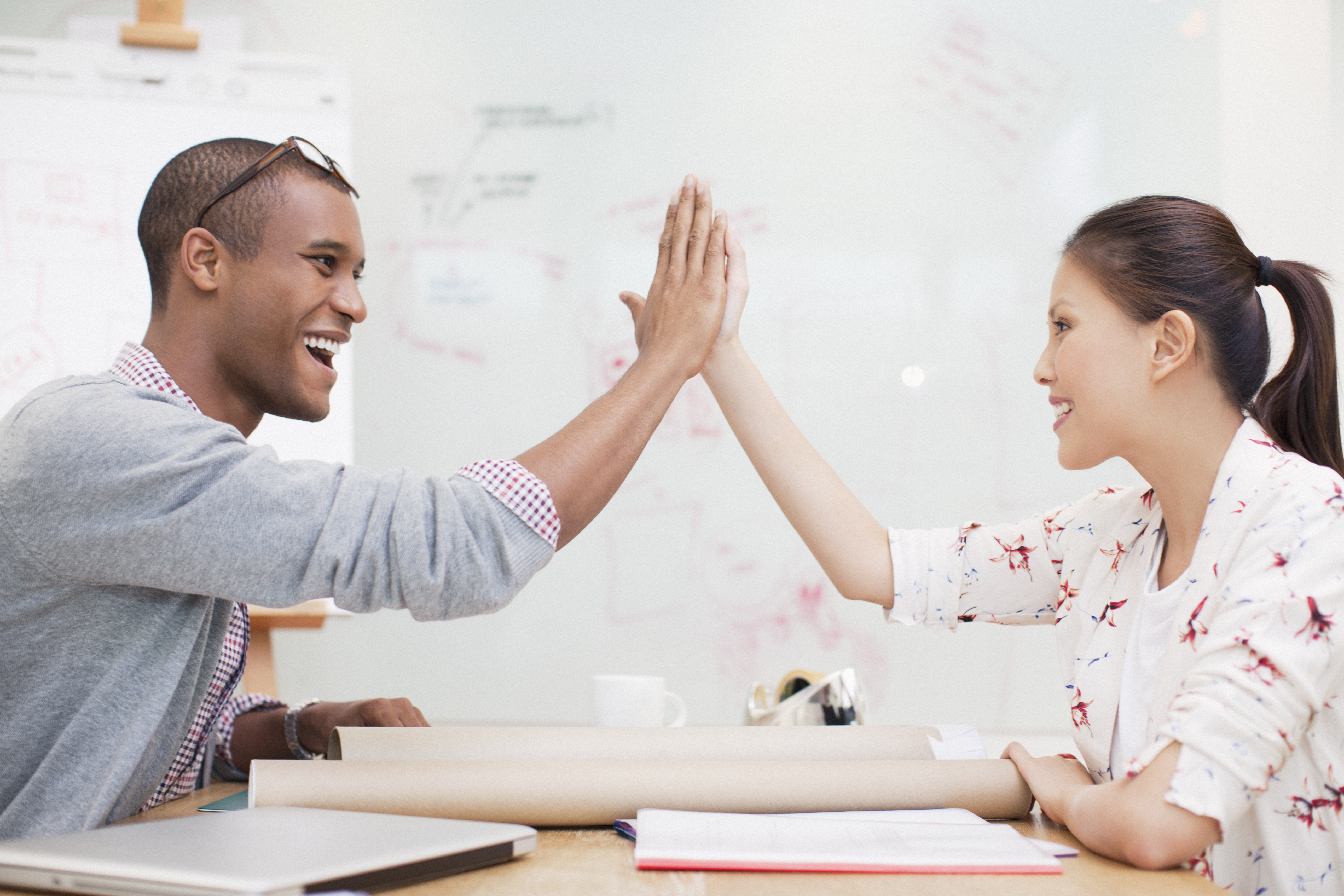 Business people high fiving in office