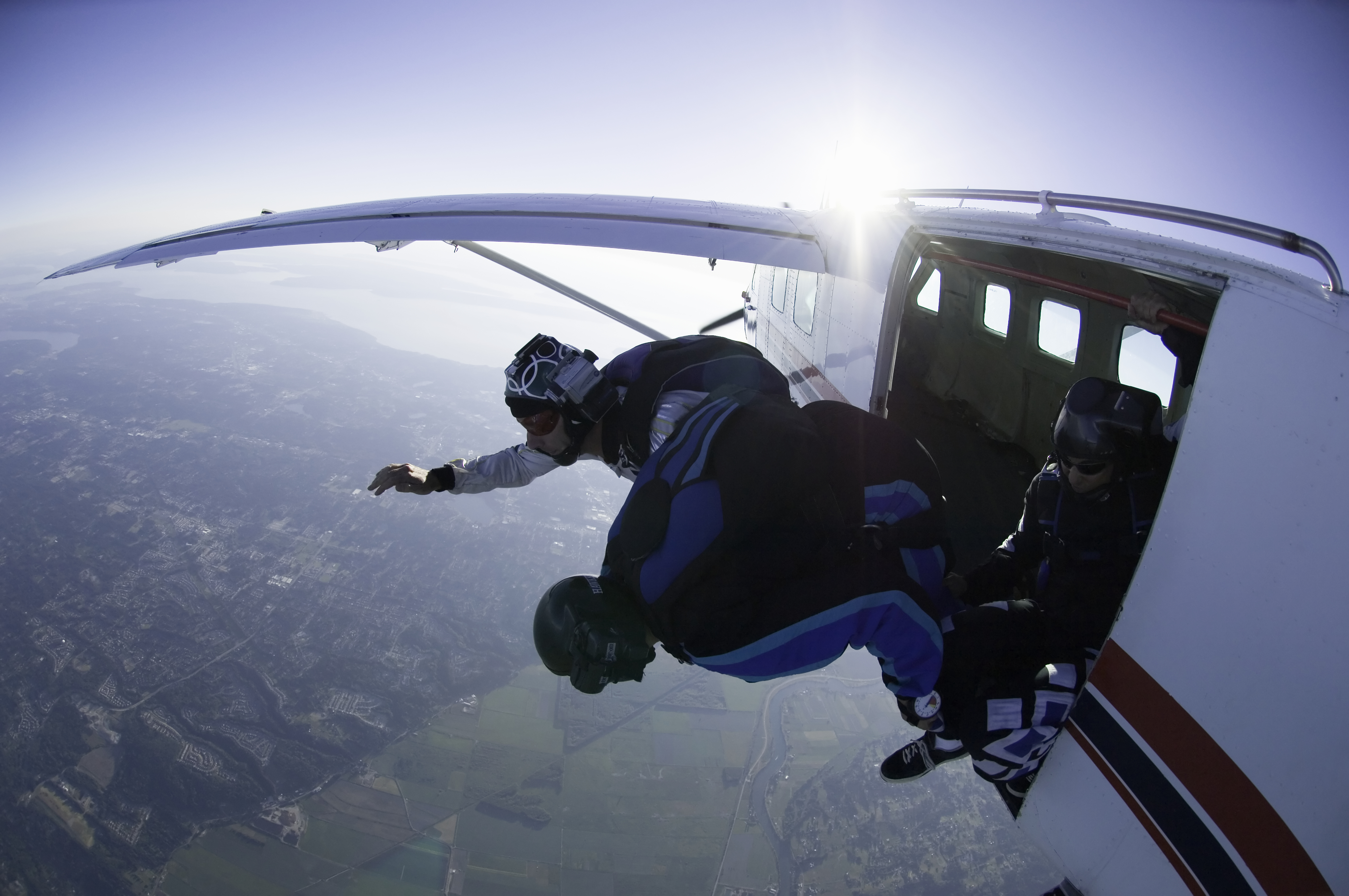 Two skydivers jumping out of airplane, aerial view