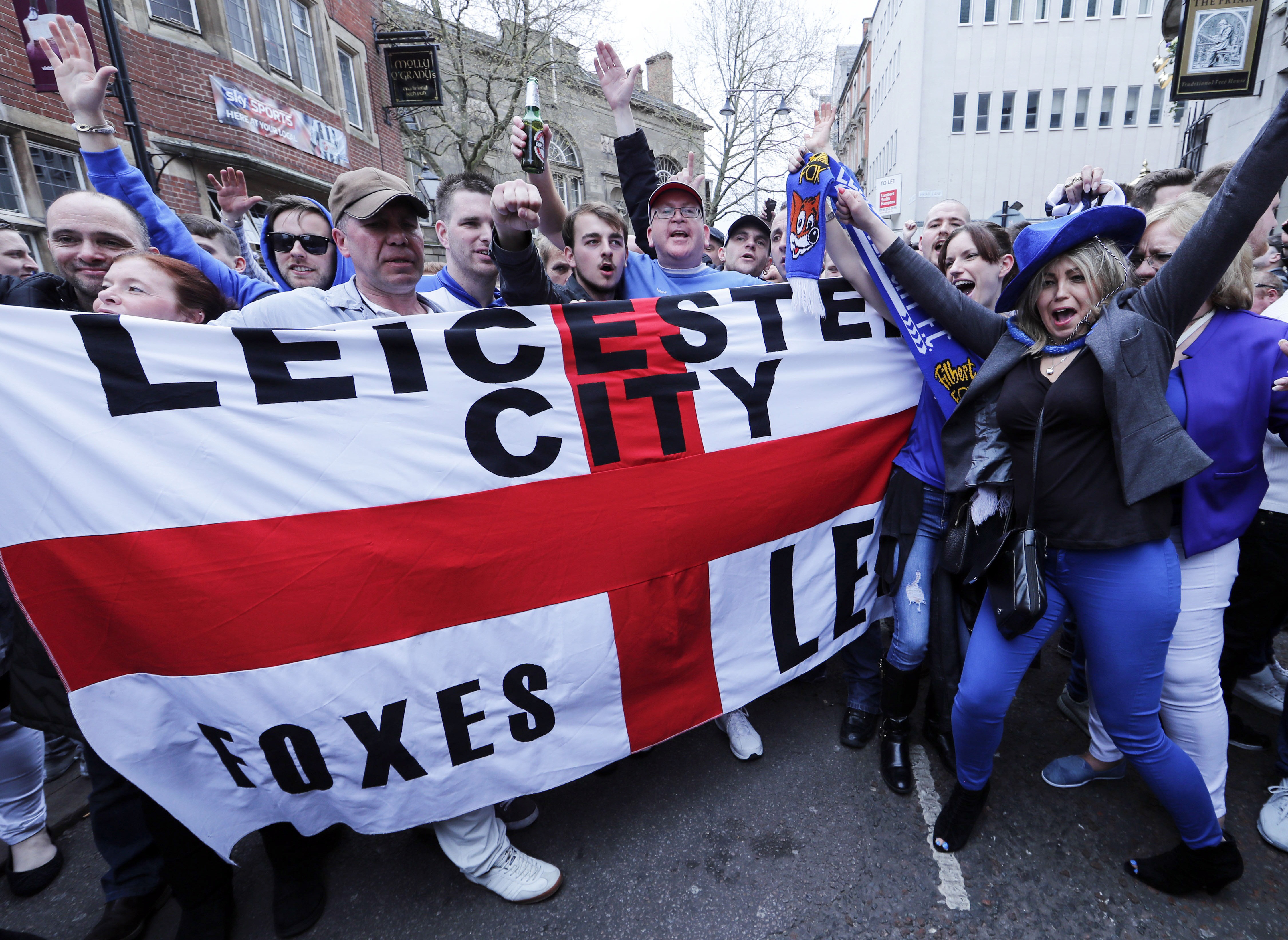 Leicester City fans celebrate in the street after their team's away soccer match against Manchester United, outside Hogarth's pub in Leicester