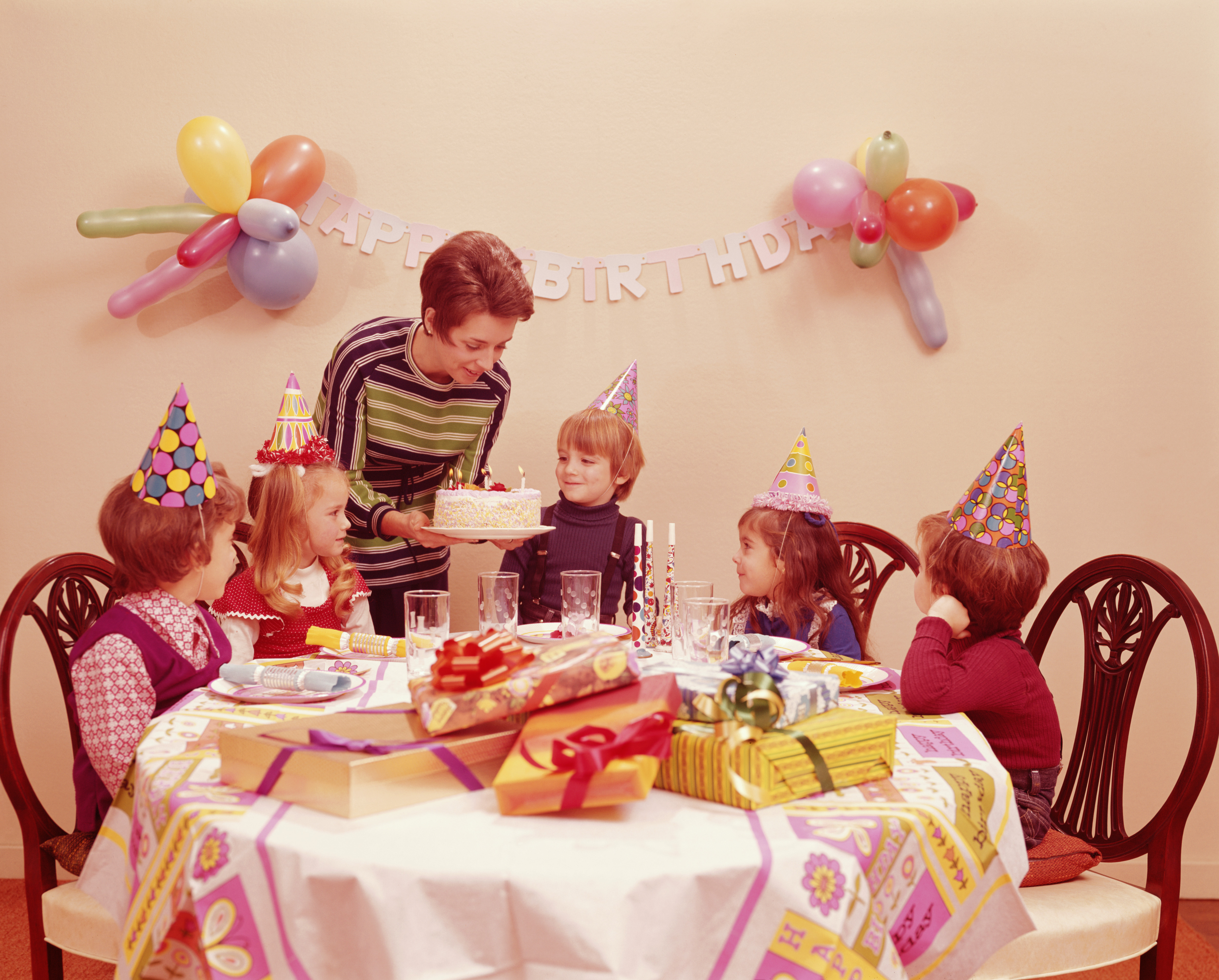 Mother serving birthday cake to children