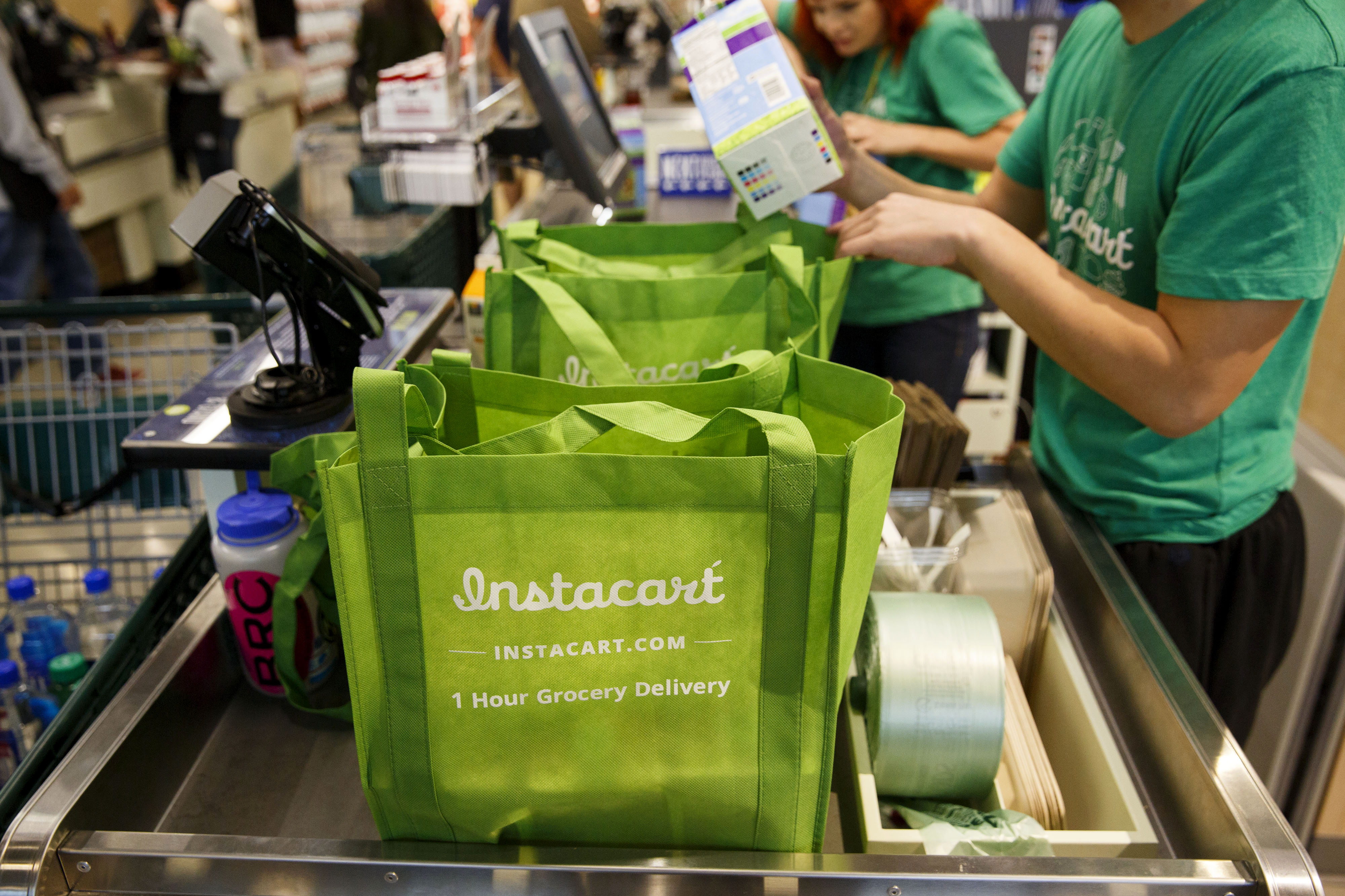 InstaCart employees fulfill orders for delivery at the new Whole Foods Market Inc. store in downtown Los Angeles, California, U.S., on Monday, Nov. 9, 2015. Located beneath the recently opened Eighth & Grand residences, the 41,000-square-foot store features a juice bar, fresh poke, expanded vegan options in all departments, a coffee bar (with cold brew on tap), more than 1,000 hand-picked wines, home delivery via Instacart and bar-restaurant The Eight Bar. Photographer: Patrick T. Fallon/Bloomberg via Getty Images